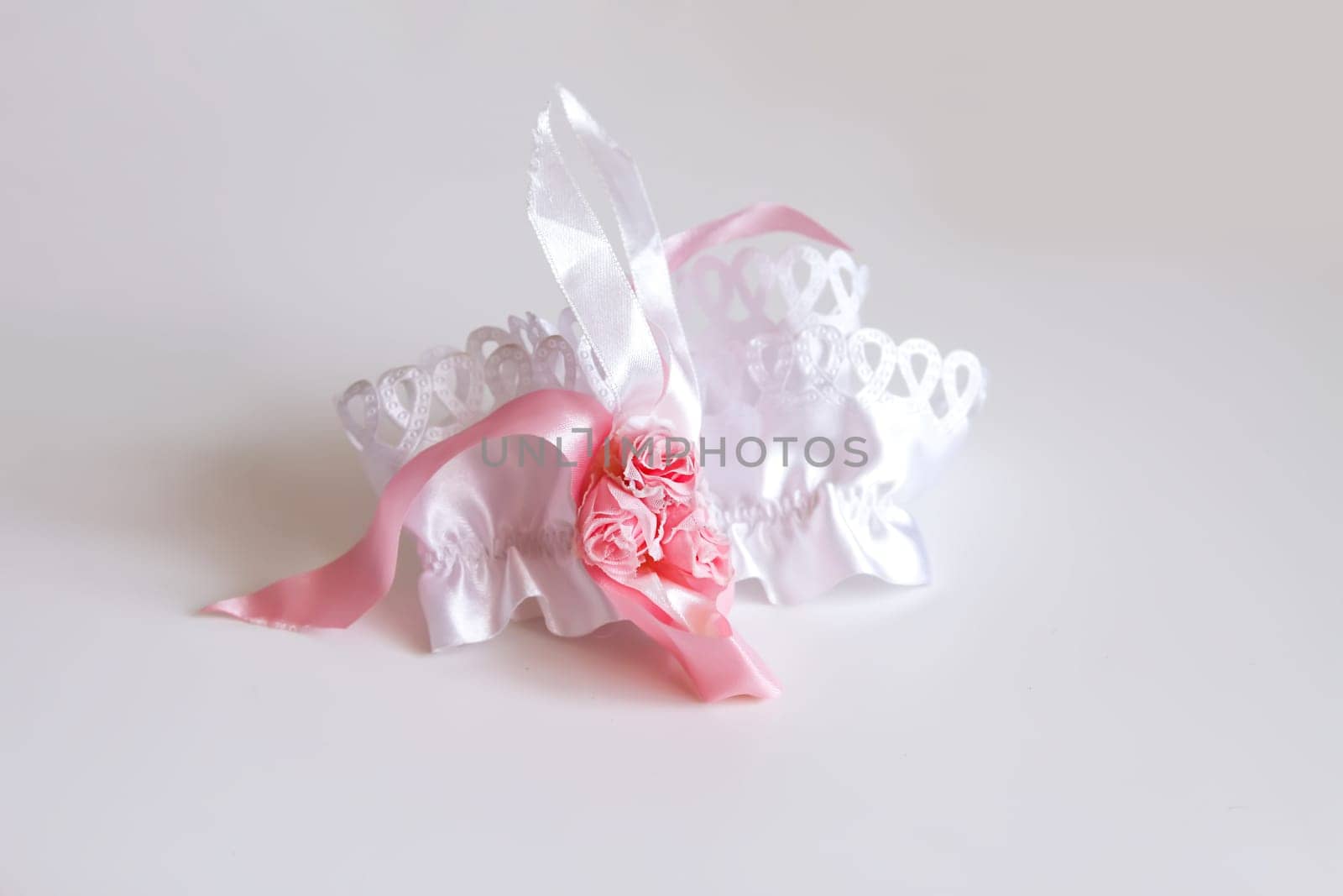 The bride's garter on a pink background. Wedding dress detail.