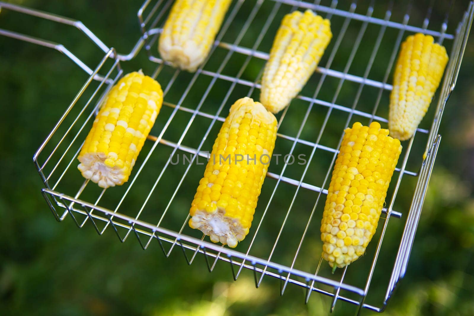 Delicious sweet corn is grilled on the grill. Outdoor recreation