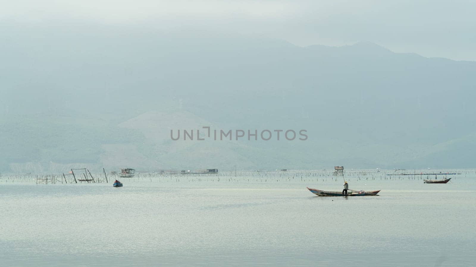 Fishing on a boat on a foggy morning against the backdrop of mountains by voktybre
