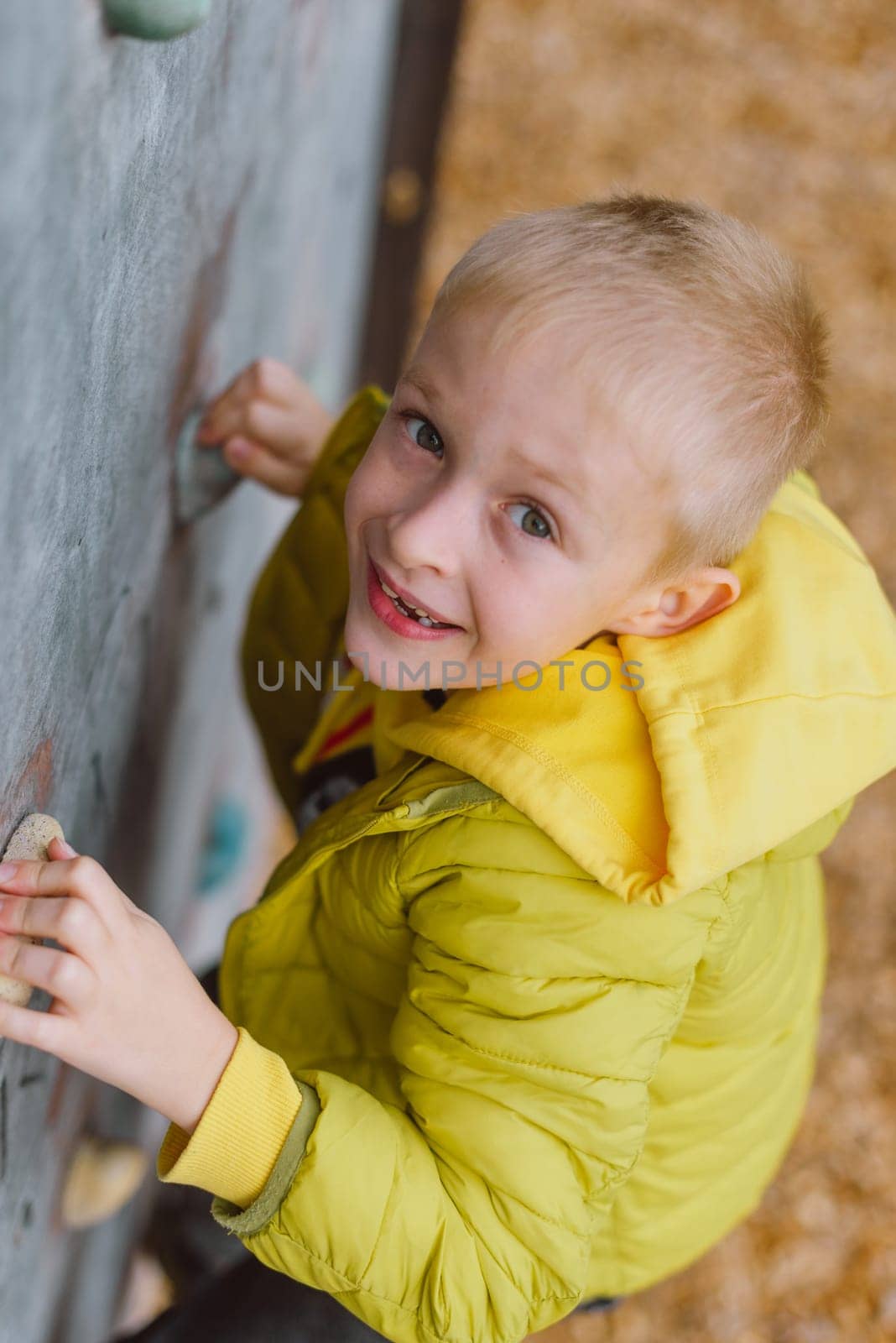 Boy at the climbing wall without a helmet, danger at the climbing wall.