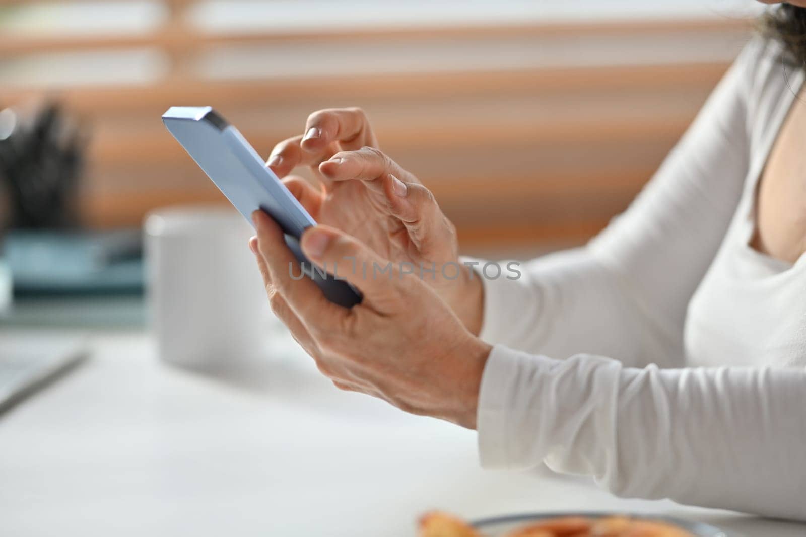 Cropped image of senior woman hand texting messages, enjoying chatting in social on smartphone.