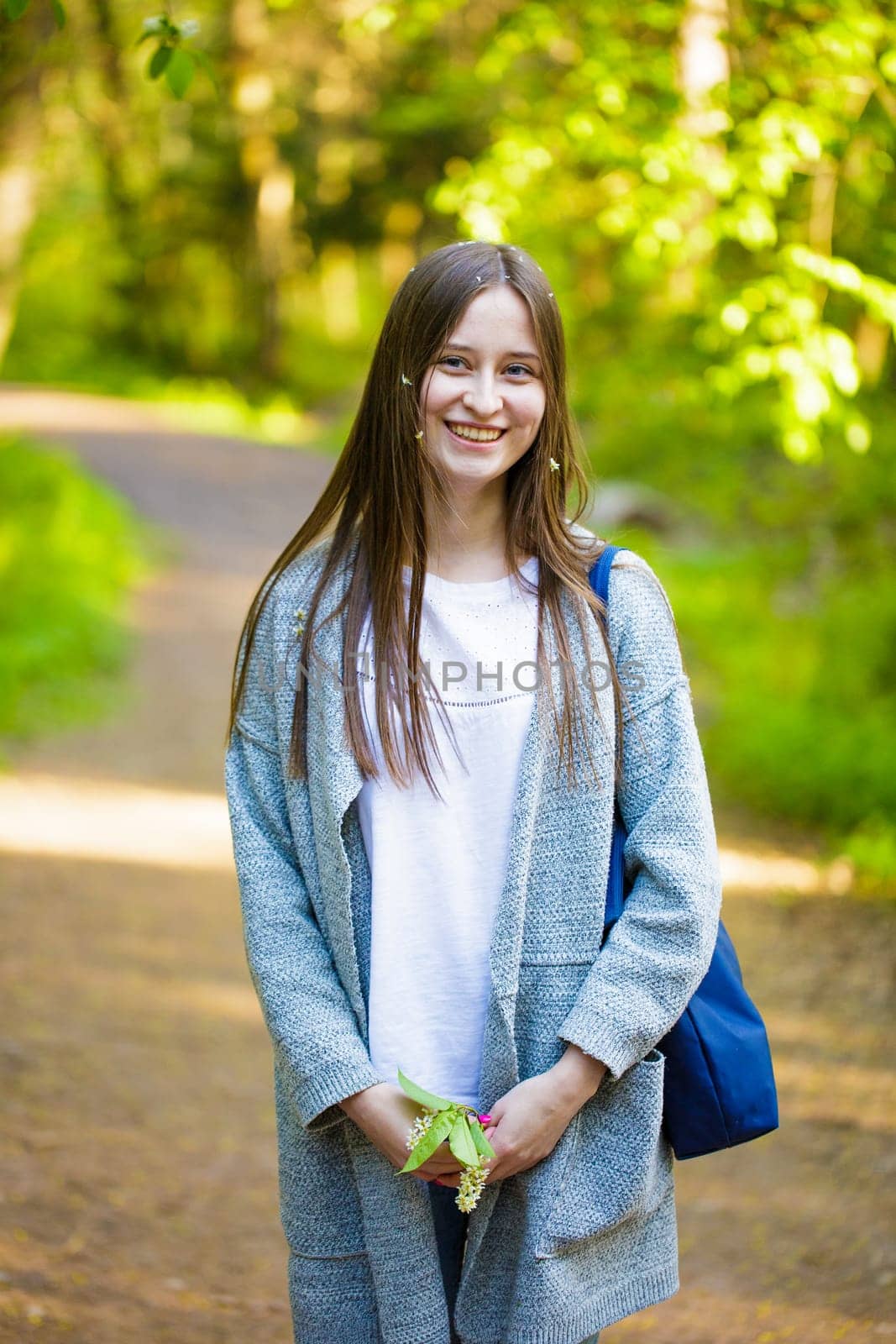 Female portrait of a young woman of Caucasian appearance stit in the park on a path in a spring day