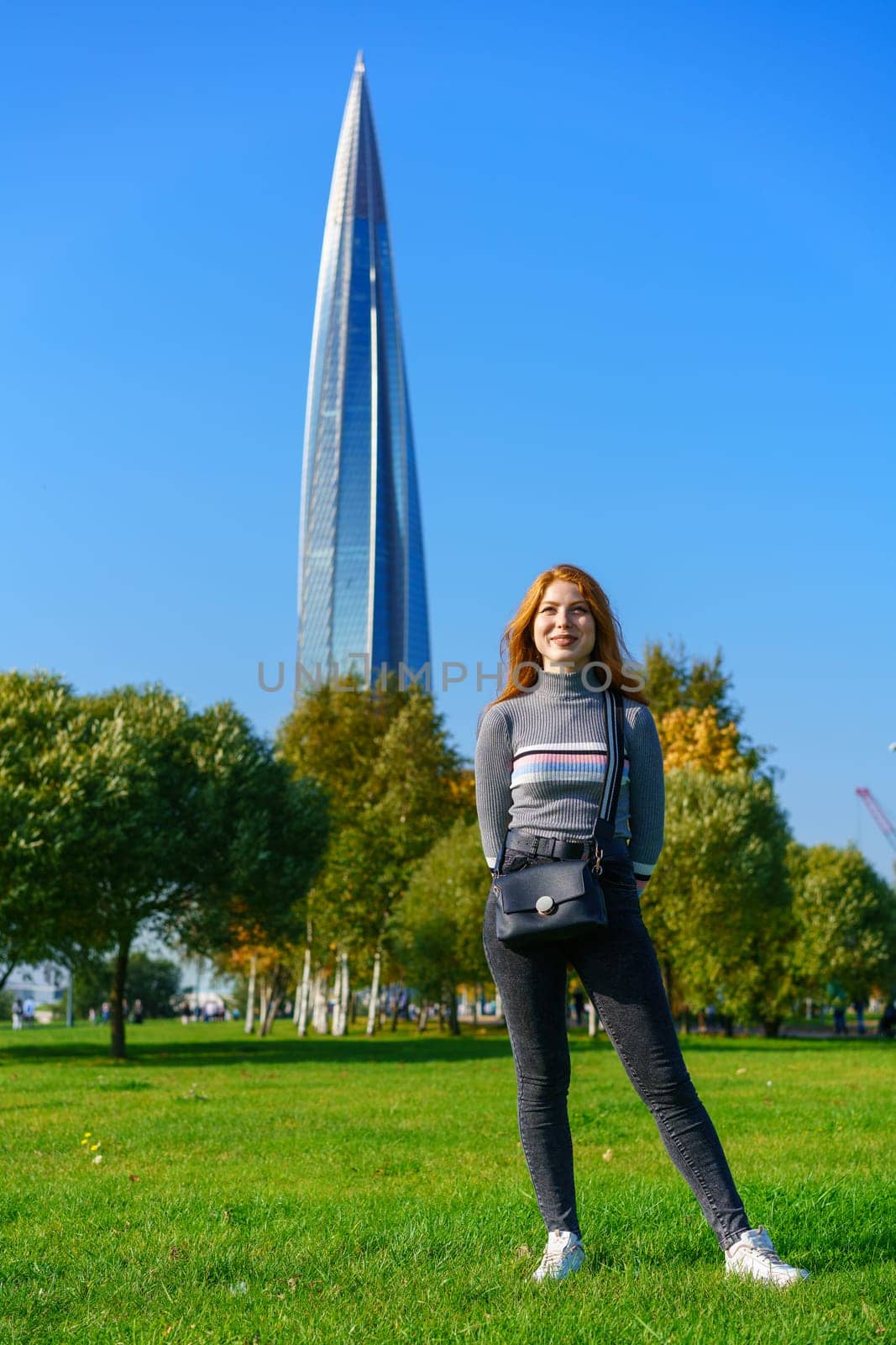 Redhead happy woman posing in the park on a sunny day by EkaterinaPereslavtseva