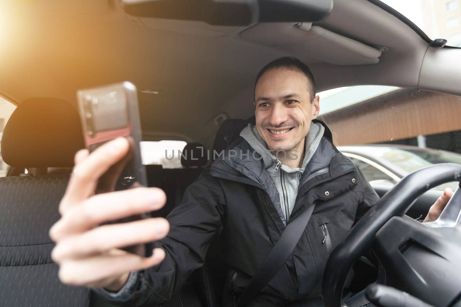 Success in motion. Handsome young man in full suit smiling while driving a car. High quality photo