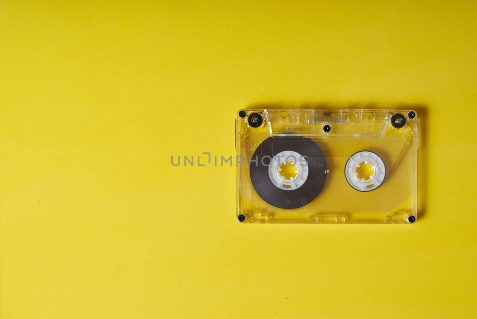 Retro cassette on a yellow background old transparent audio cassette is located on a yellow background