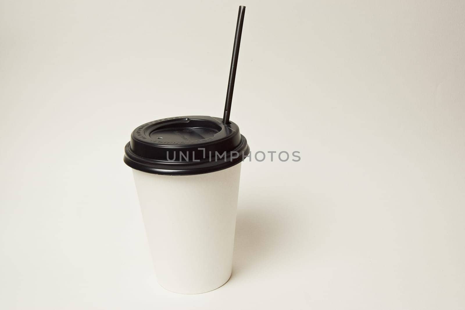 Paper coffee container with black lid and coffee beans on a white background white coffee paper cup with black lid takeaway coffee
