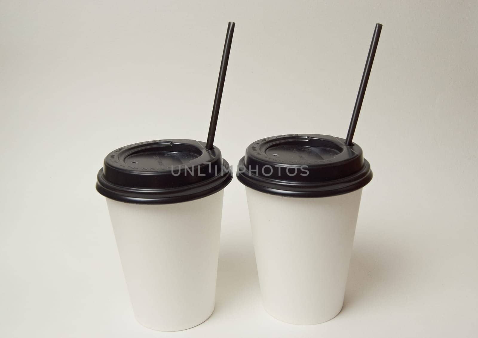 Paper coffee container with black lid and coffee beans on a white background white coffee paper cup with black lid takeaway coffee