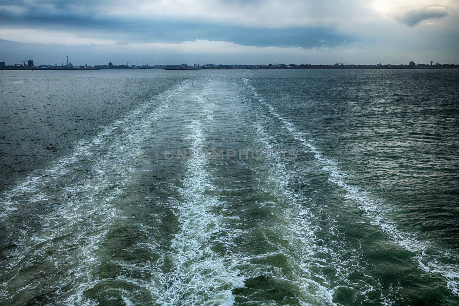 a cruise ship leaving the harbor as seen from the railing by compuinfoto