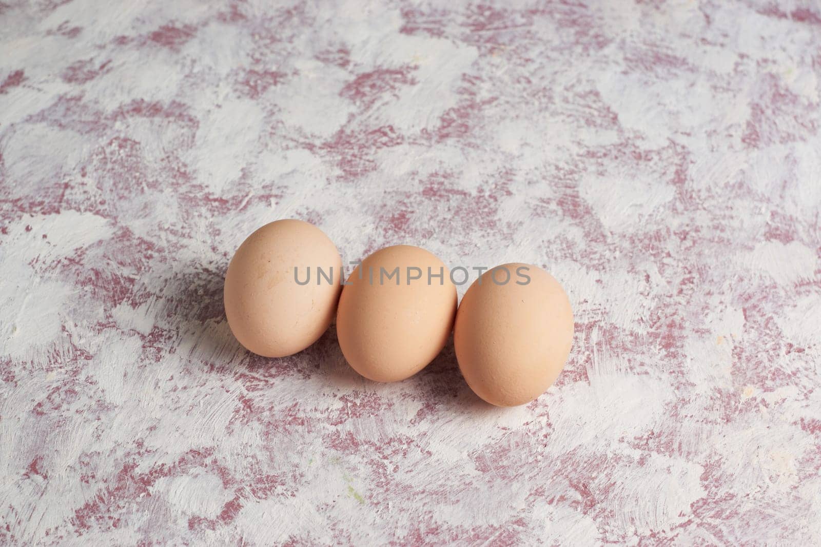 Three red Easter brown eggs on a light background. Colorful decoration of Easter eggs. Flat position, top view. with a place to copy the text. Minimal idea for an Easter concept.
