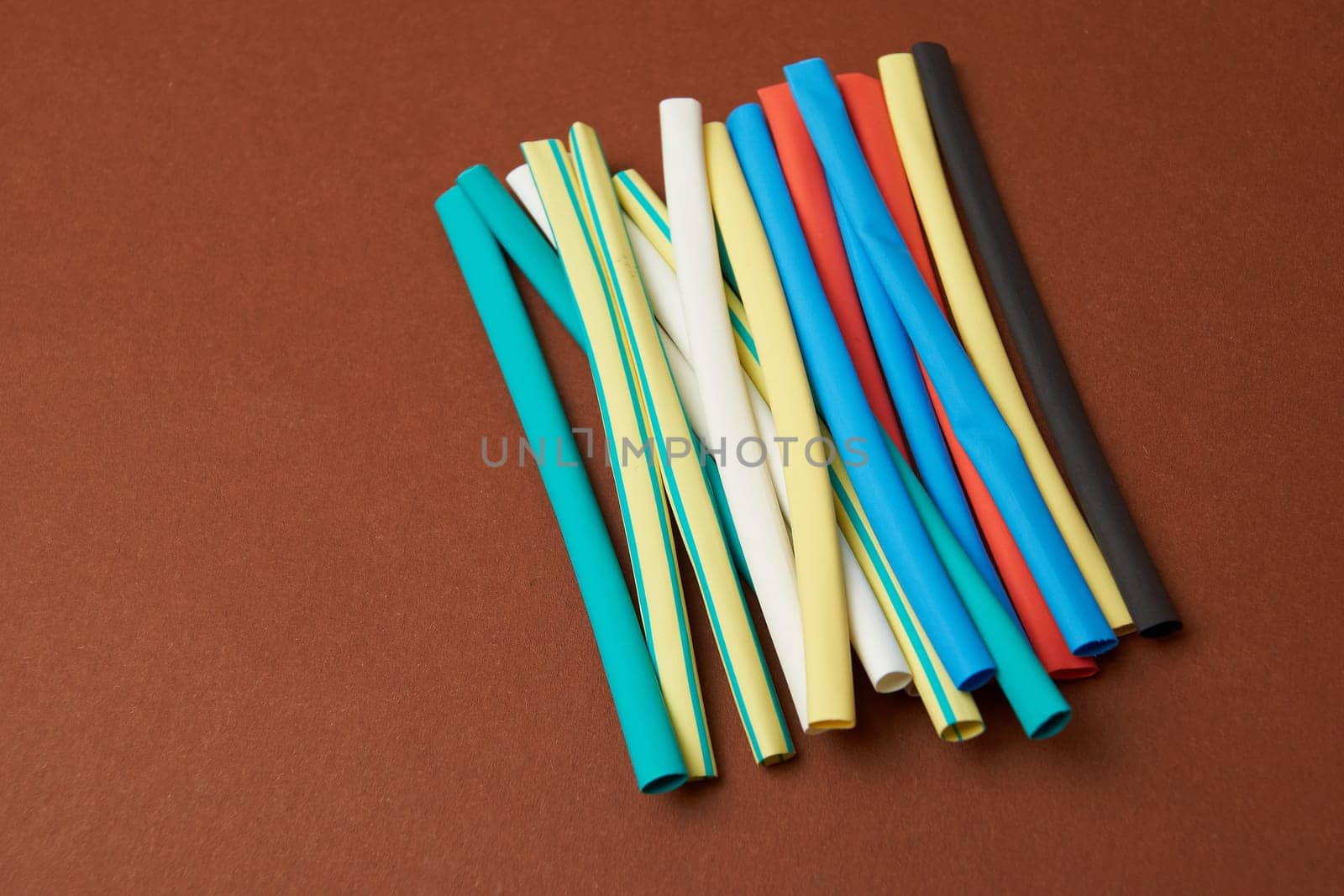 Multicolored shrink tube on a brown background tubes of different colors