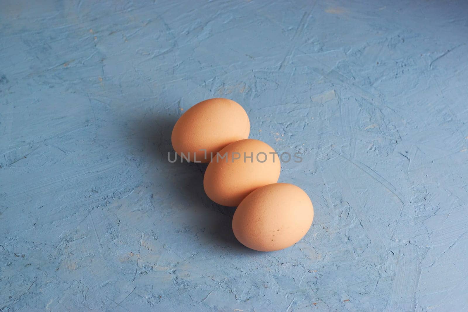Three red Easter eggs on a blue background. Colorful decoration of Easter eggs. Flat position, top view. with a place to copy the text. Minimal idea for an Easter concept.