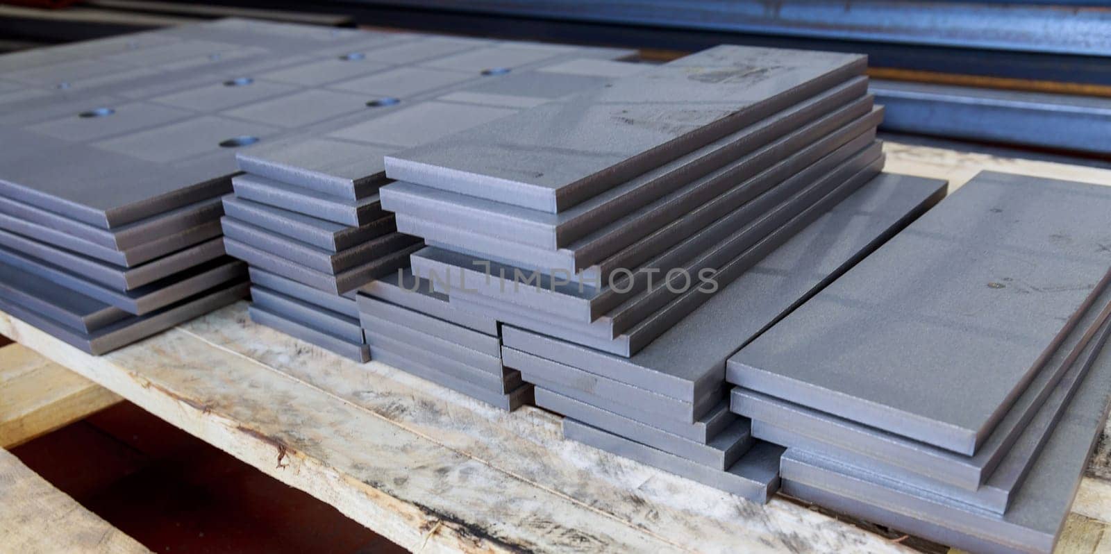 The metal parts are cleaned of rust and stacked on a pallet. A thick sheet of metal cut on a plasma cutting machine.