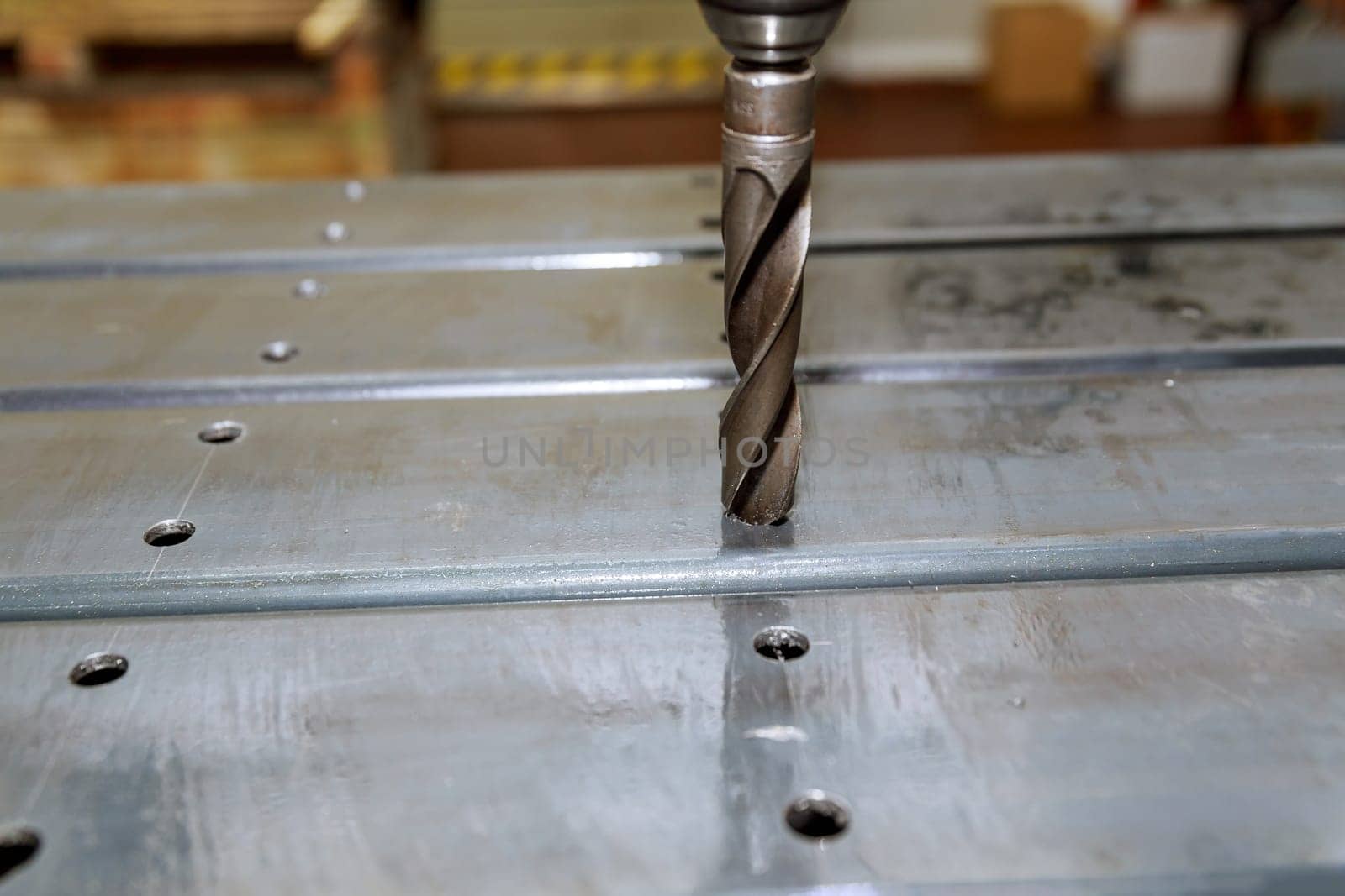 Processing of metal products and drilling holes. Heavy work and metalworking concept. Drilling holes in metal pillars.