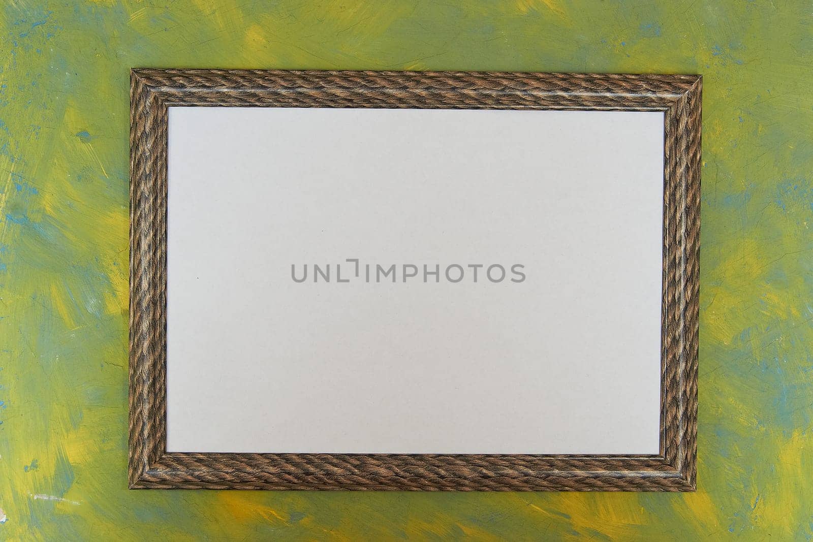 wooden brown photo frame with a white monochrome photo on an abstract yellow-green background