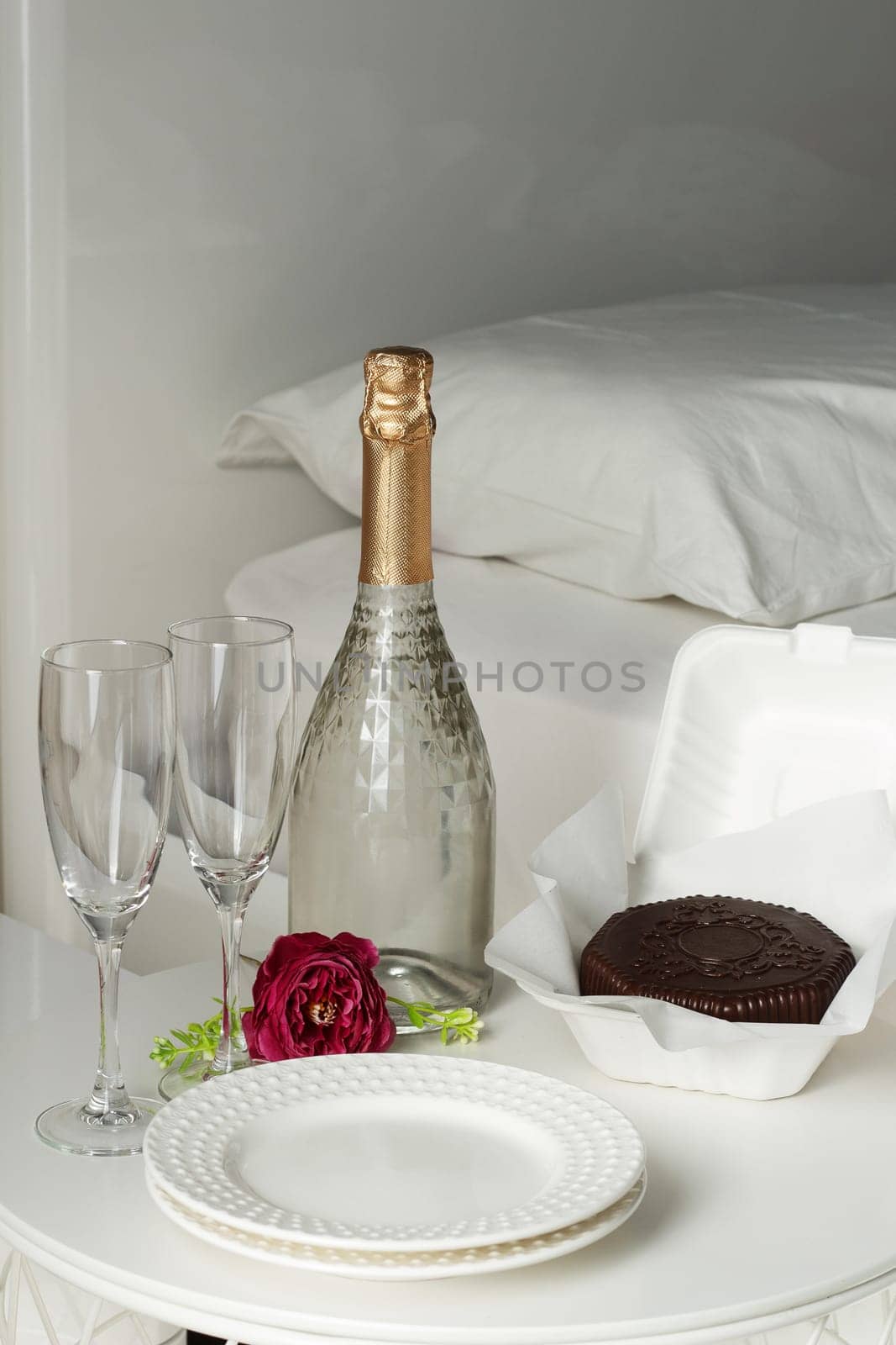 Two glasses with a bottle of champagne and a chocolate dessert in a luxury hotel room. Dating, romance, honeymoon, Valentine's day. by lara29