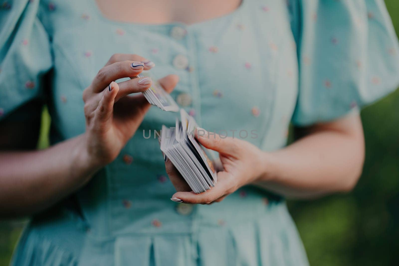 Woman shuffles tarot deck, preparation for consultation on predicting future destiny. Fortune teller, medium, divination cards.