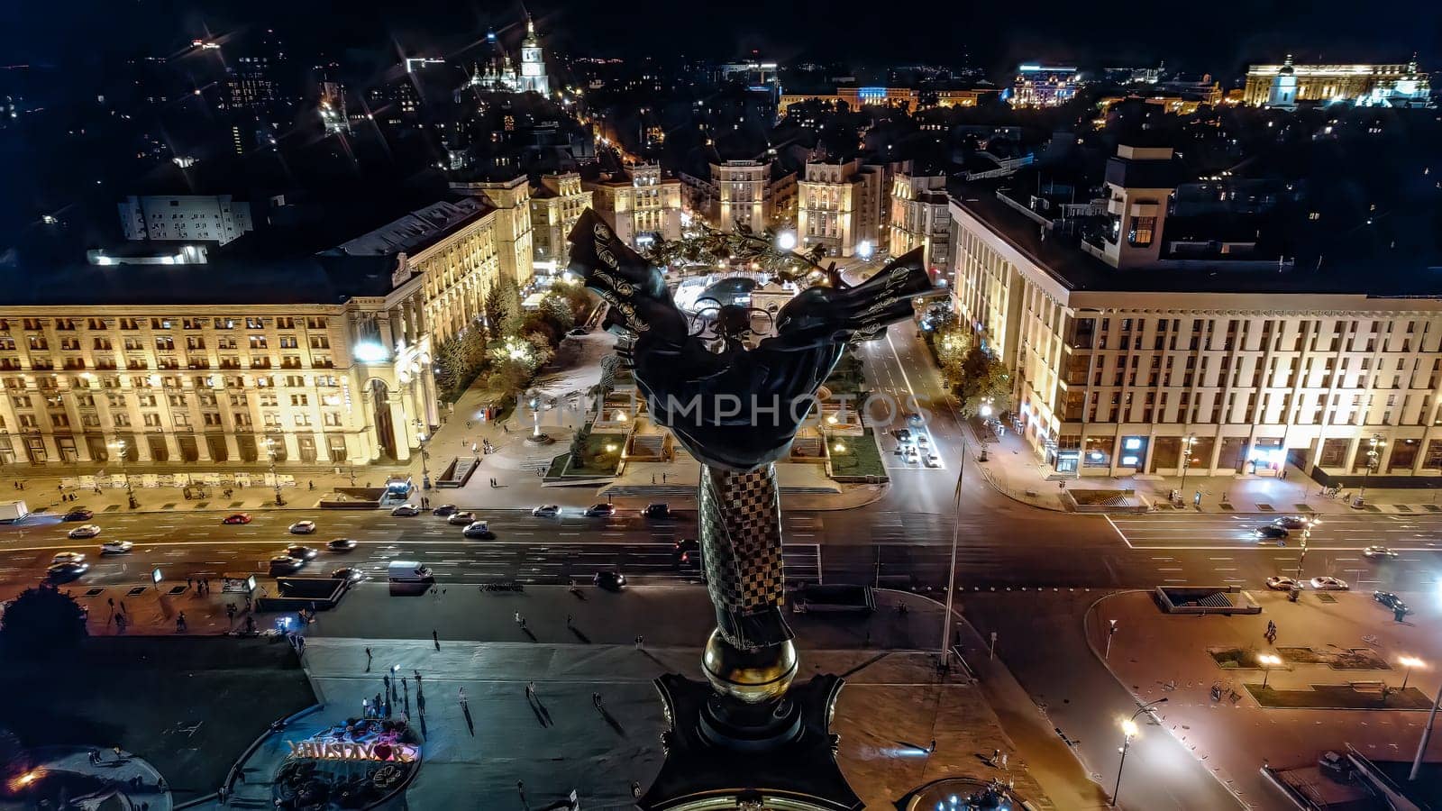 Kyiv, Ukraine - April, 2023: Maidan Nezalezhnosti square at night - aerial drone view. Monument of Independence - Berehynia in the center. Golden beautiful Ukrainian woman statue.