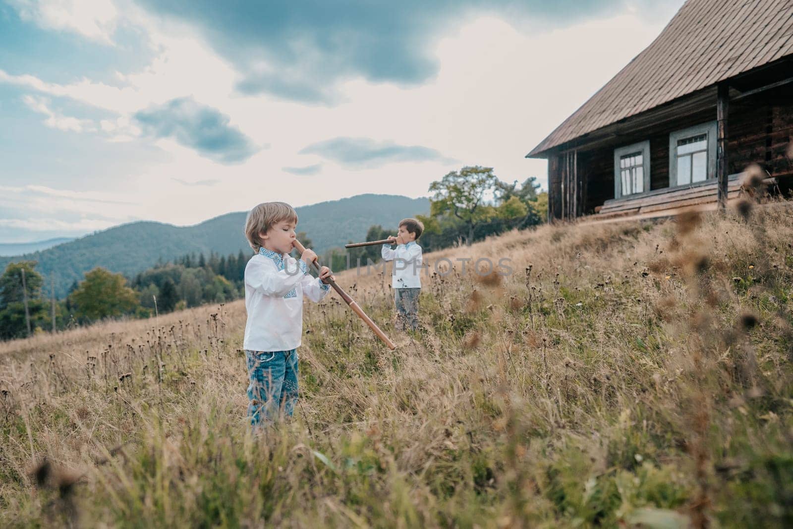 Little boys playing on flutes - ukrainian sopilka on meadow Carpathian mountain by kristina_kokhanova