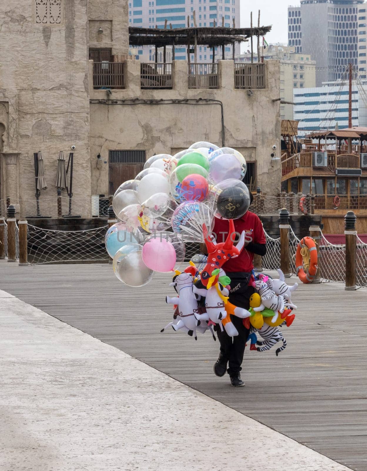 Street trader with balloons and animal toys on Al Seef boardwalk in Dubai, UAE