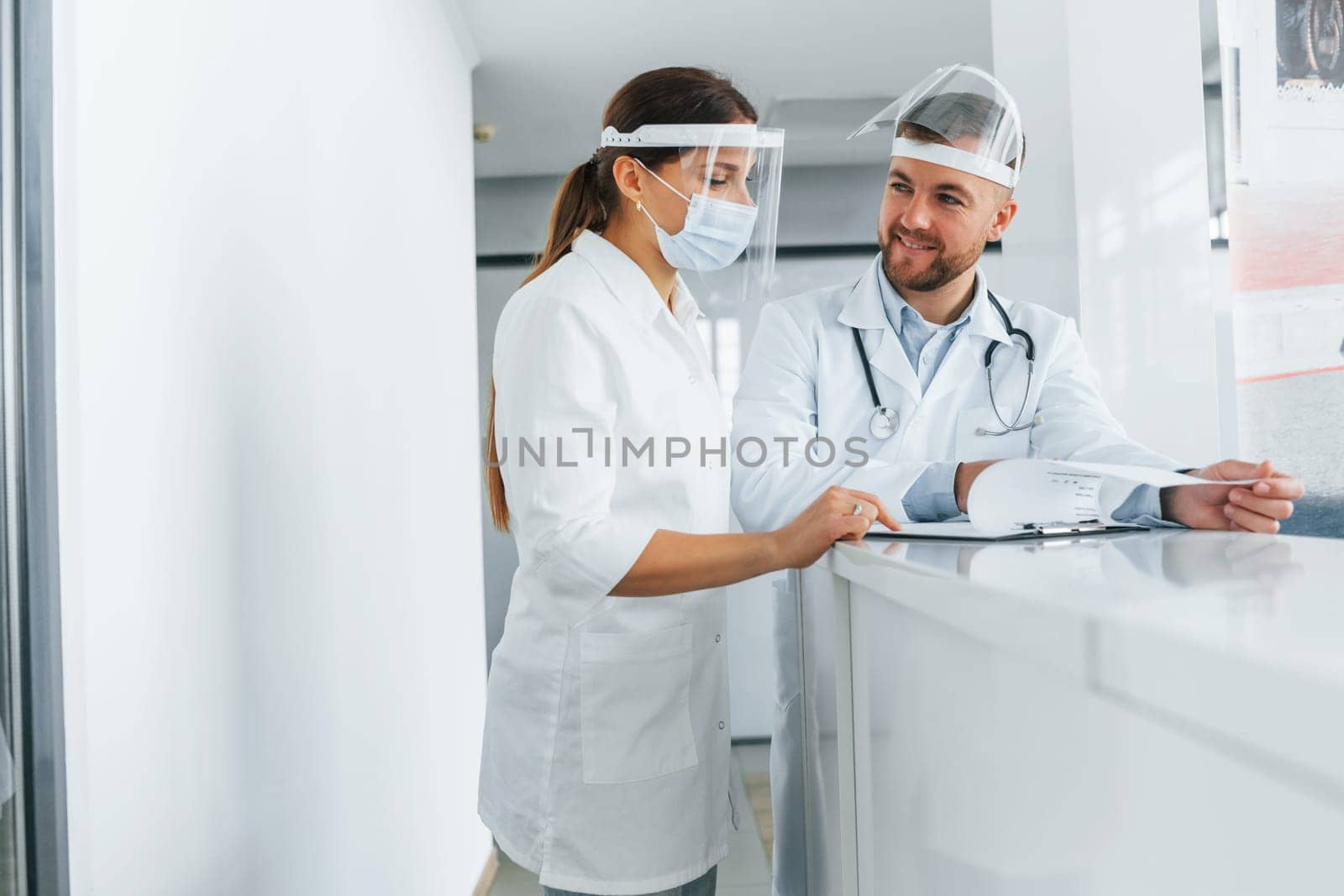 Talking with each other. Two doctors in white coats is in the clinic working together.