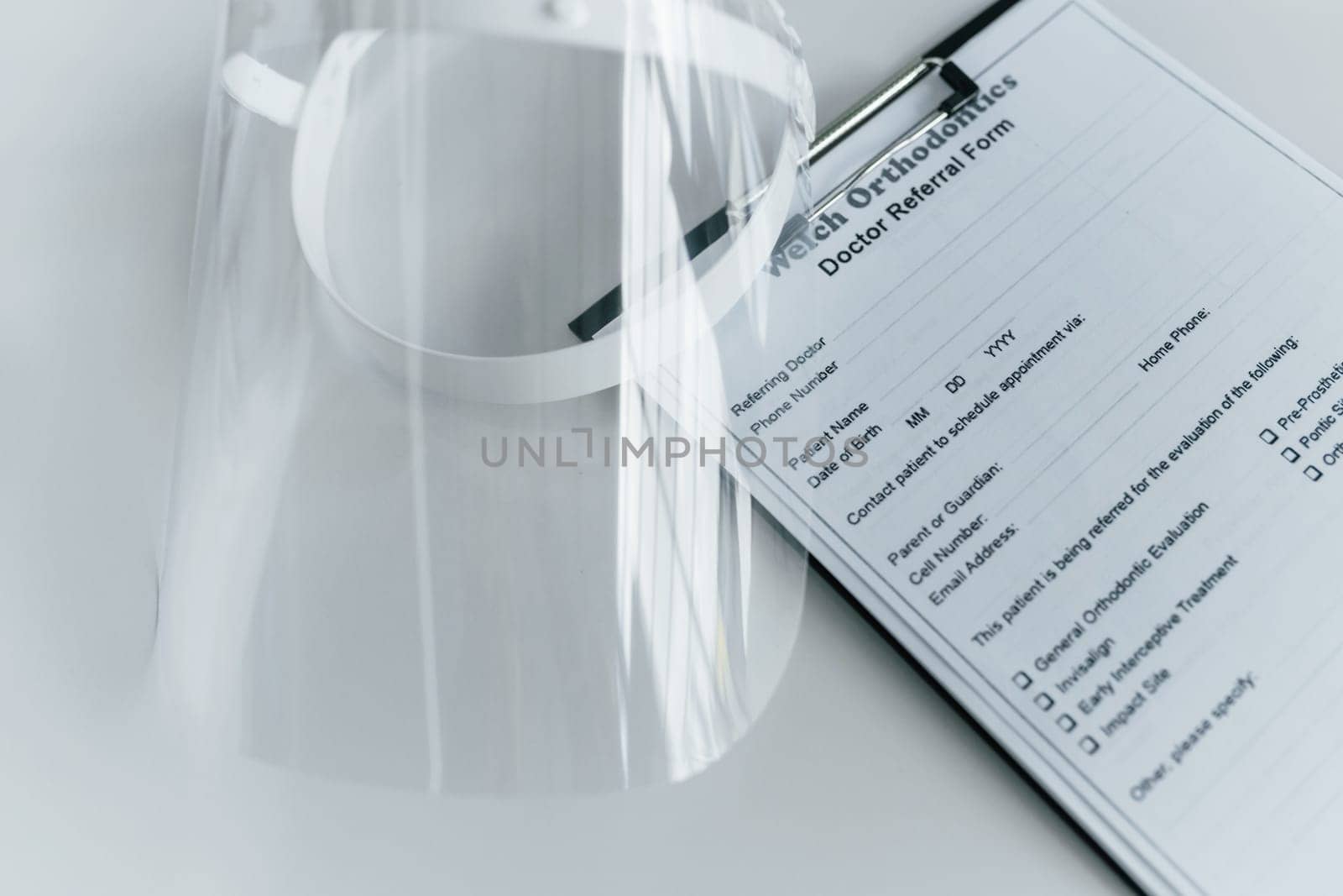 Close up view of protective mask and medical agreement that is on the white table.