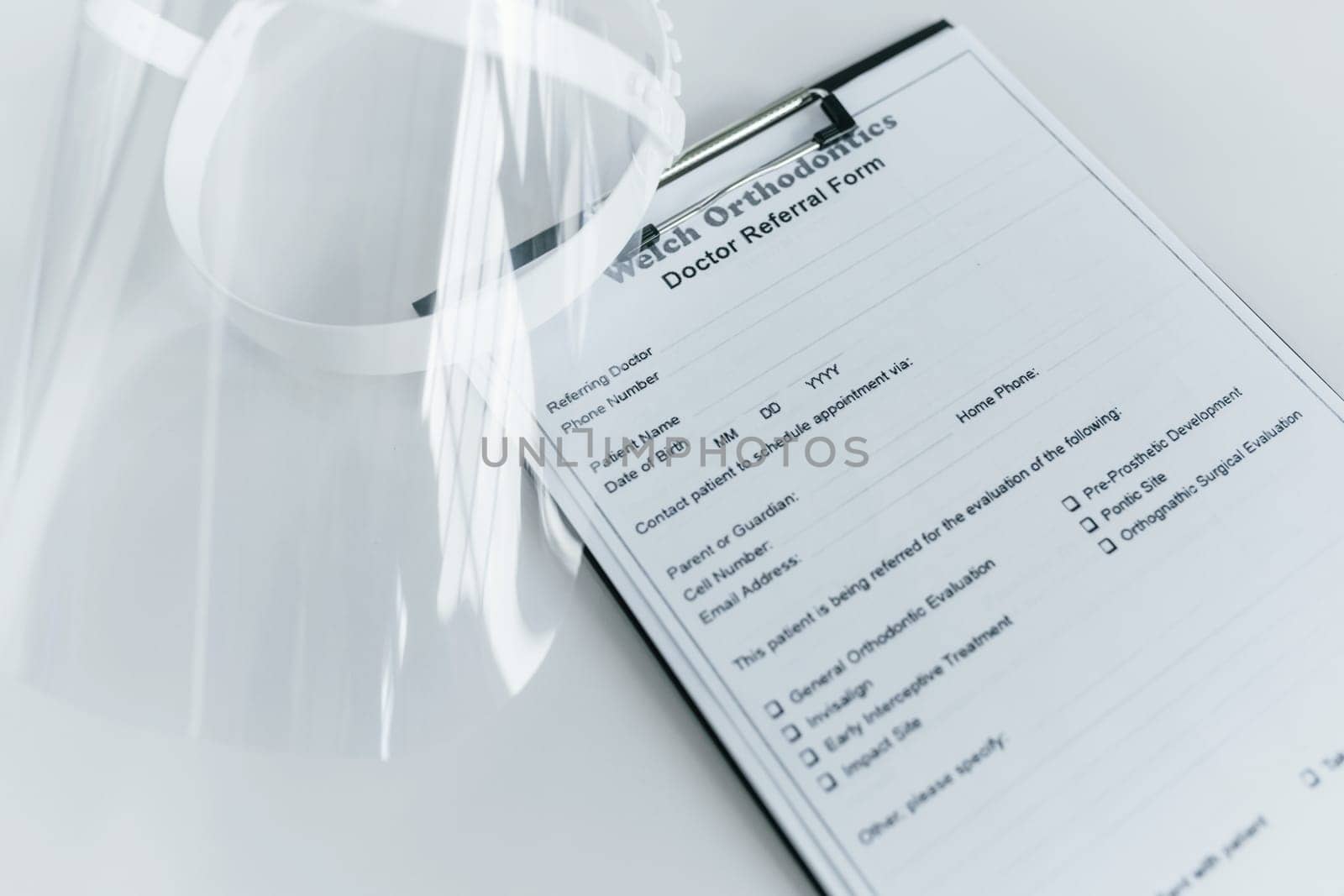 Close up view of protective mask and medical agreement that is on the white table.