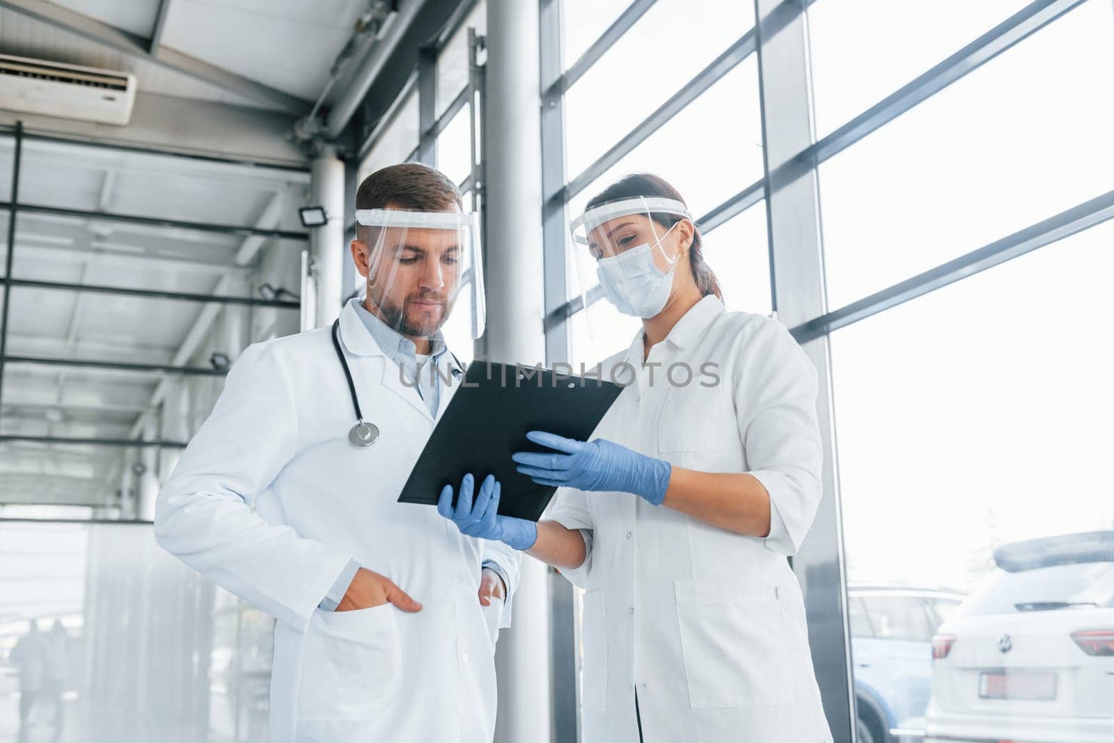 Working with documents. Two doctors in white coats is in the clinic.