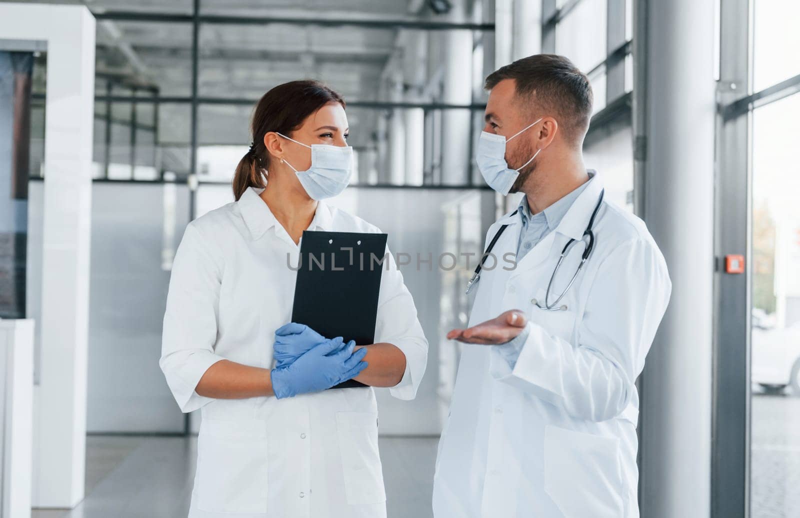 Having busy day. Two doctors in white coats is in the clinic working together.