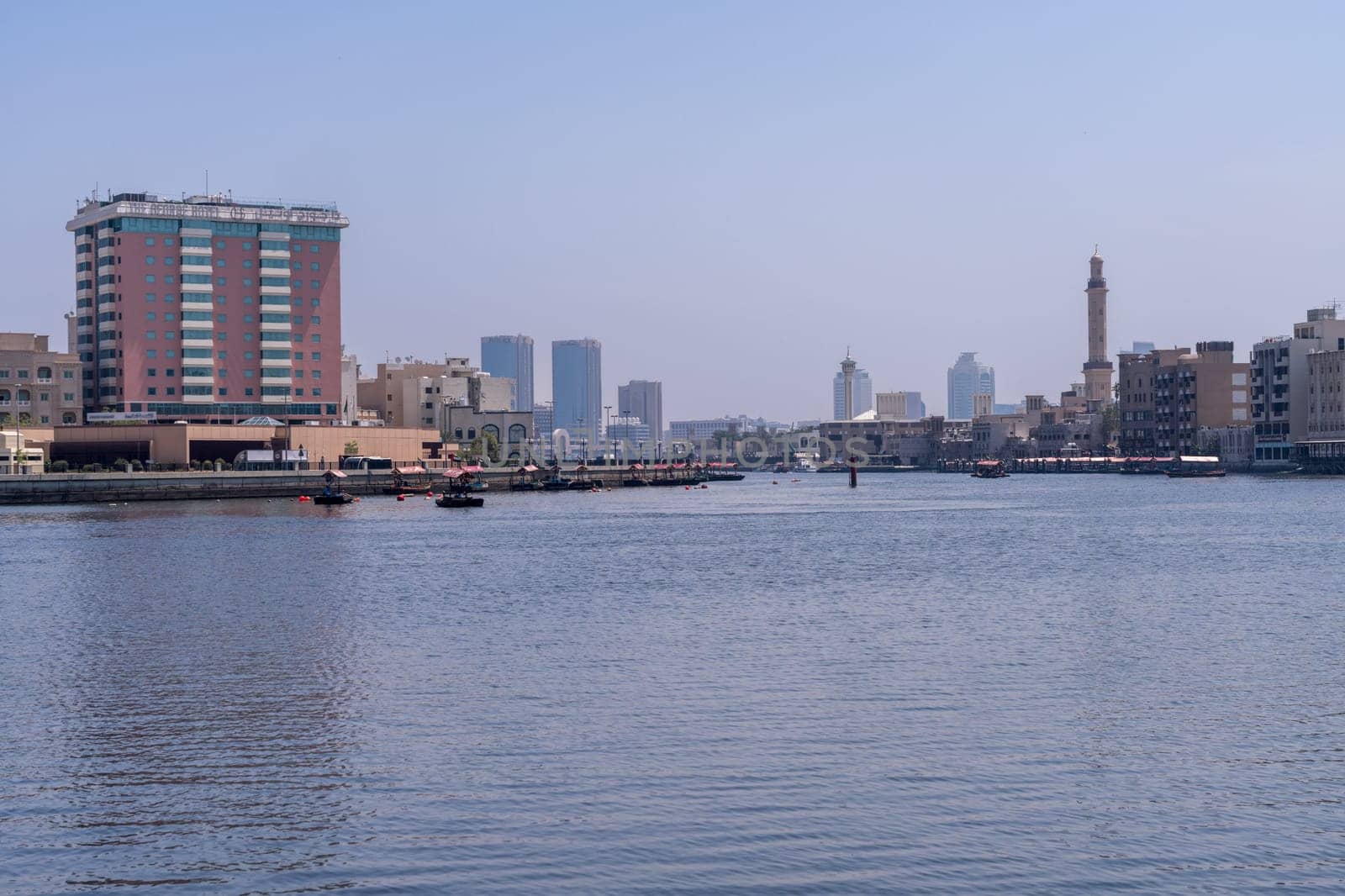 Dubai, UAE - 31 March 2023: The Creek from Bur Dubai to Deira with traditional Abra docked on the waterfront