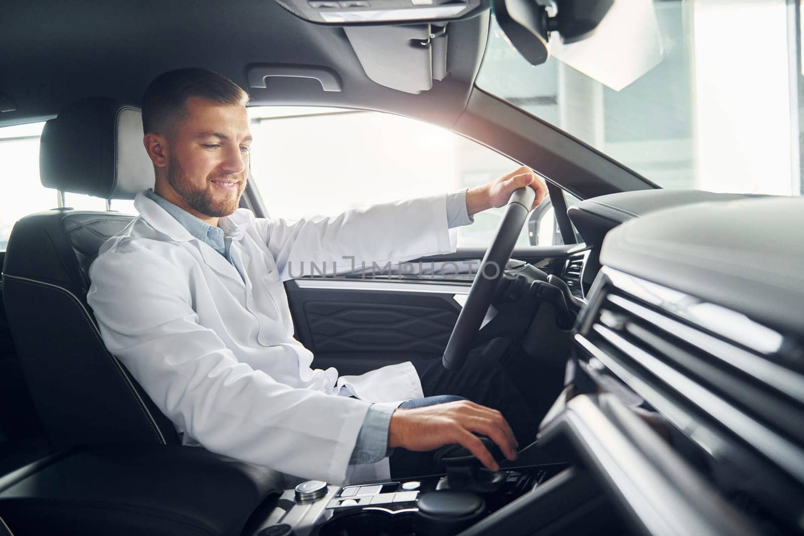 Man in white coat is driving the car.