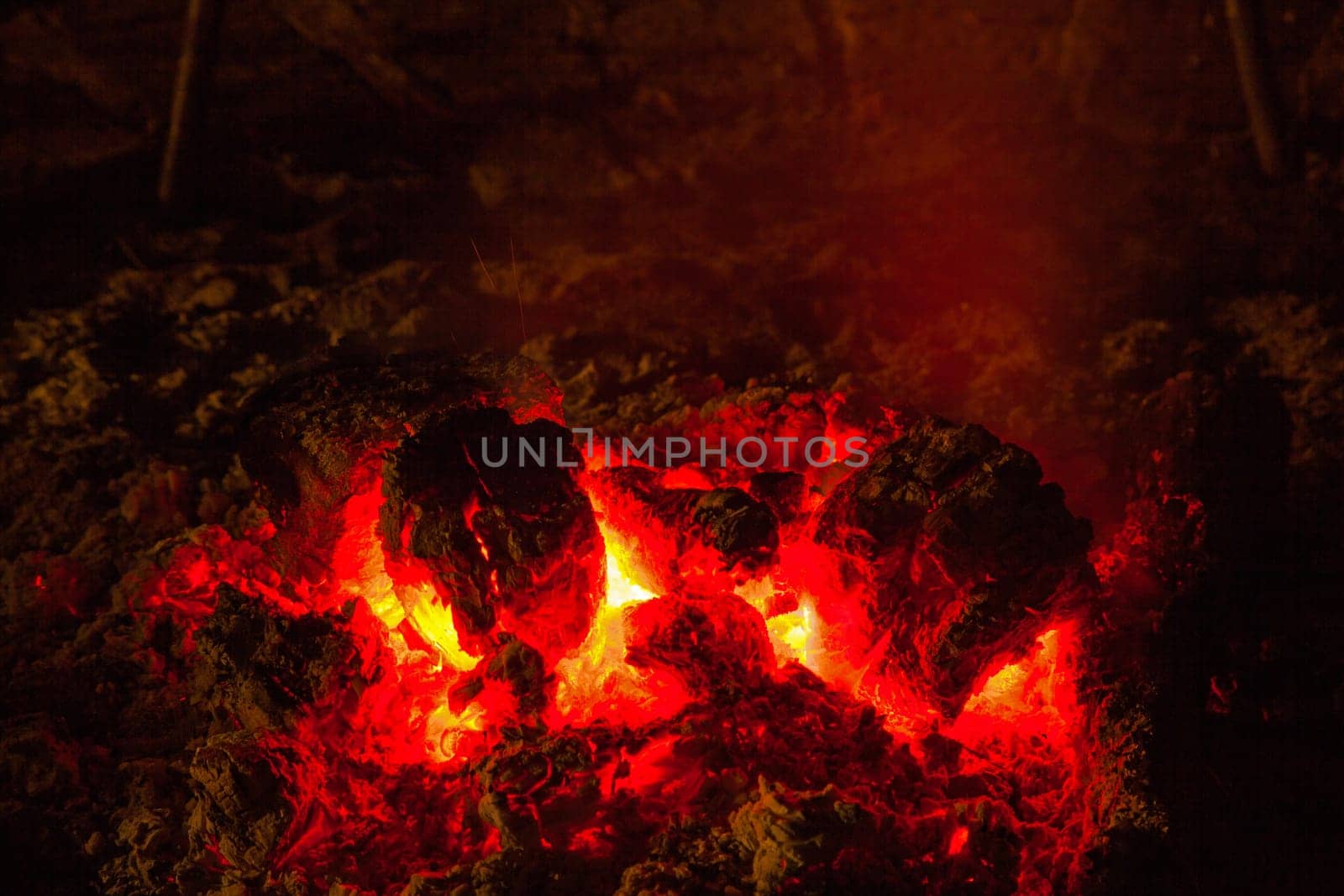 The red hot glowing embers after the flames of a campfire burnt out