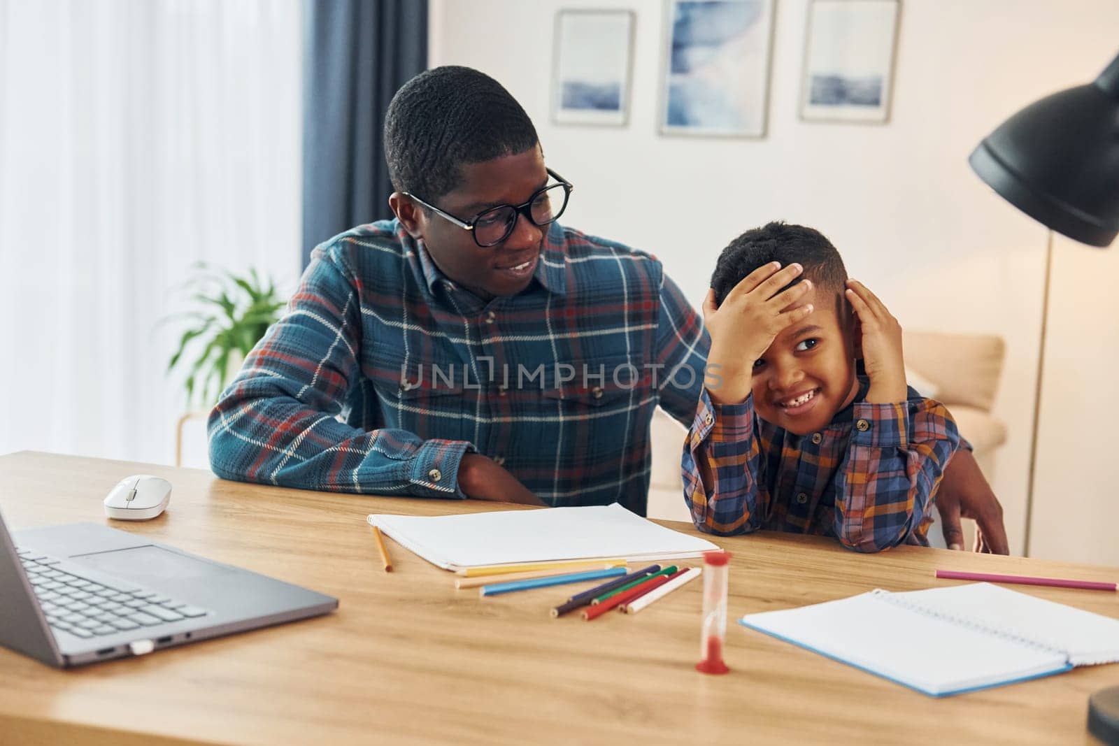 Cheerful family. African american father with his young son at home.