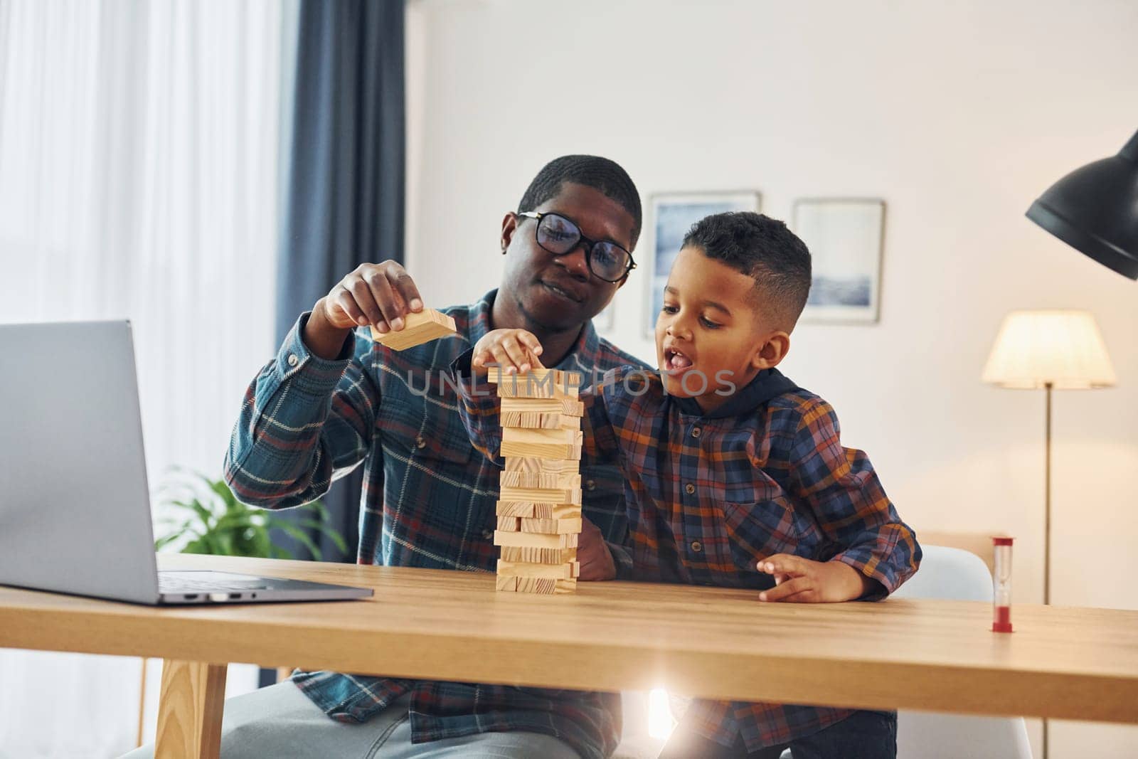 Cheerful family. African american father with his young son at home.