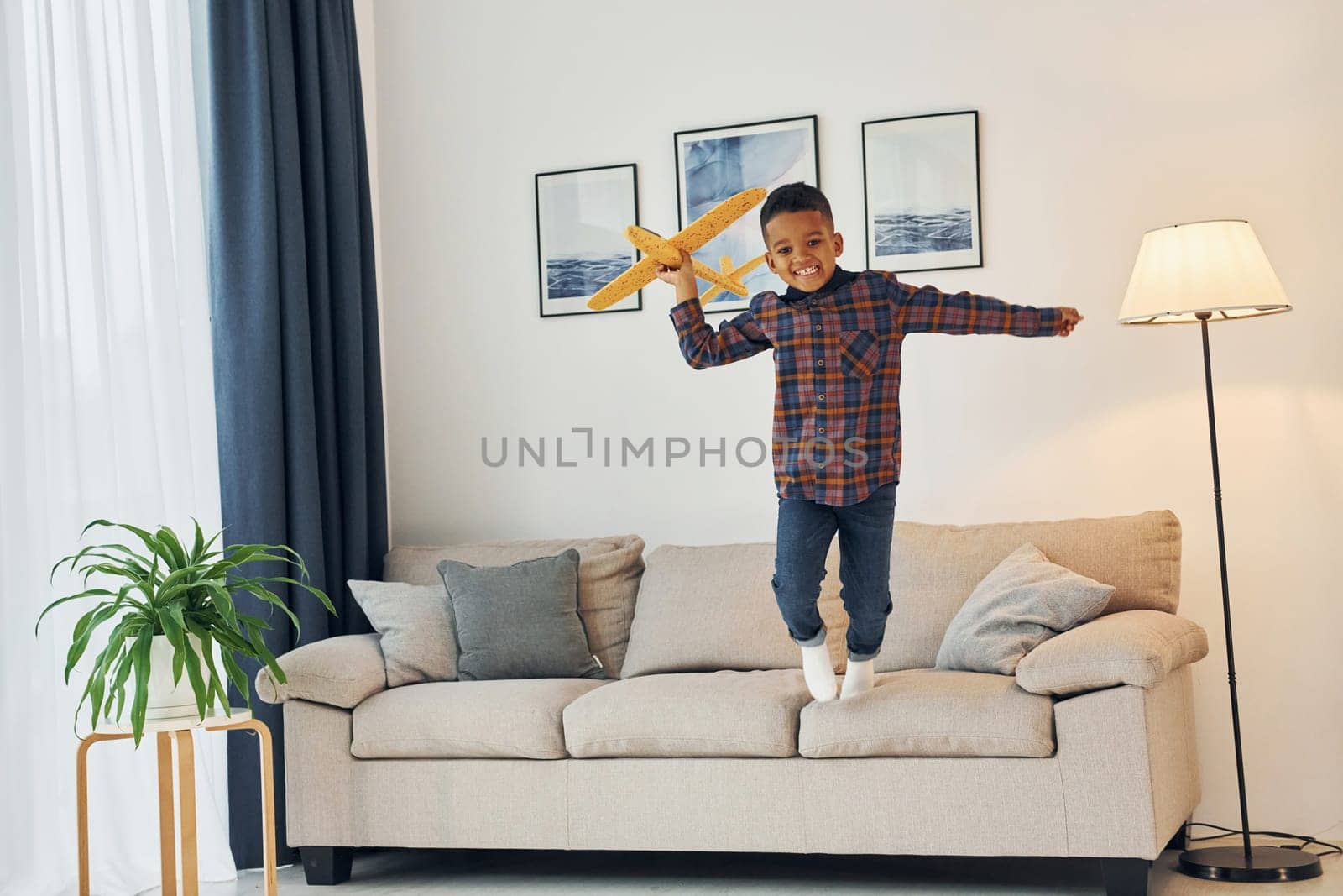 Having fun. Cheerful young boy is at home alone.
