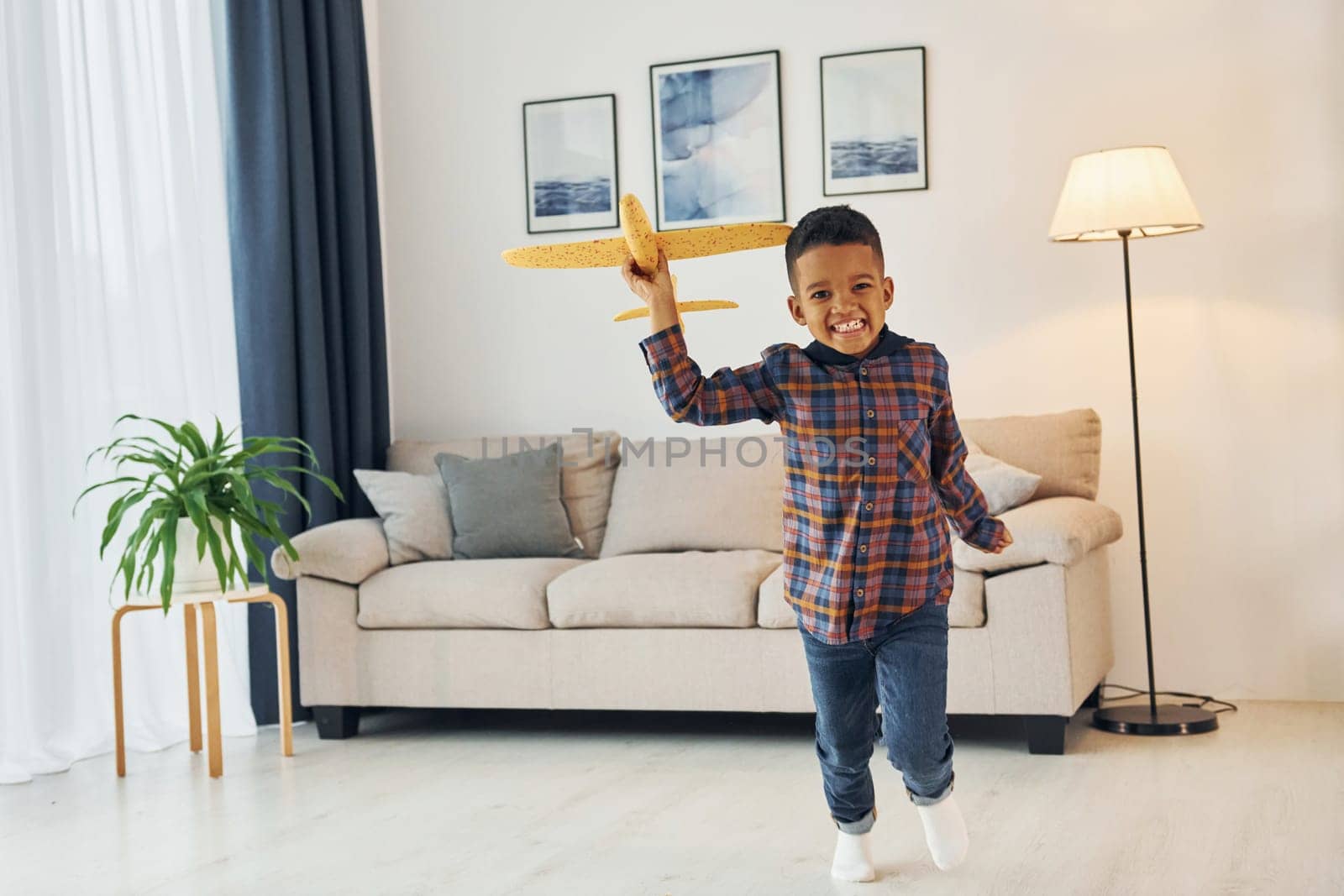 Having fun. Cheerful young boy is at home alone.