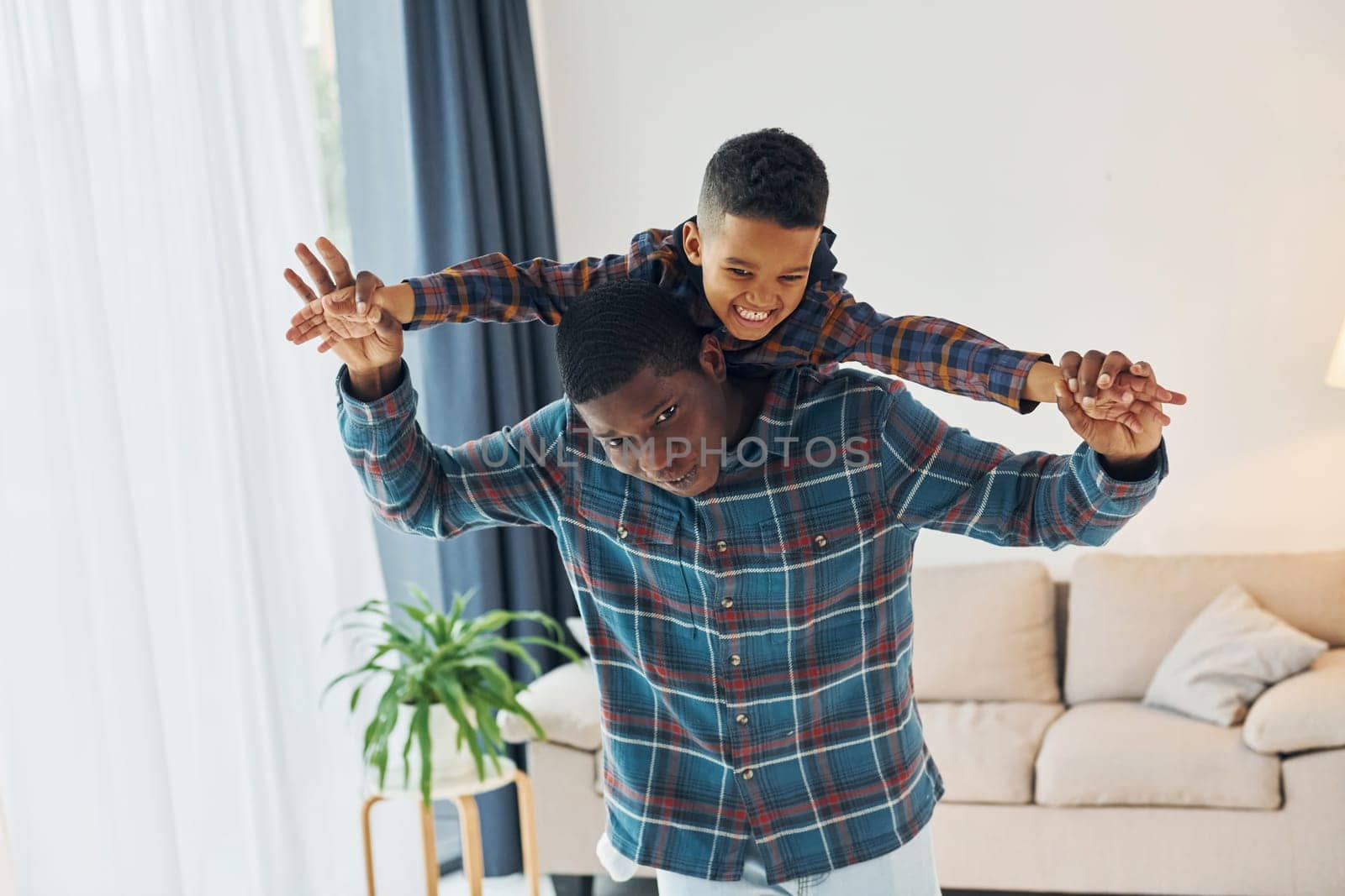 Having fun. African american father with his young son at home.