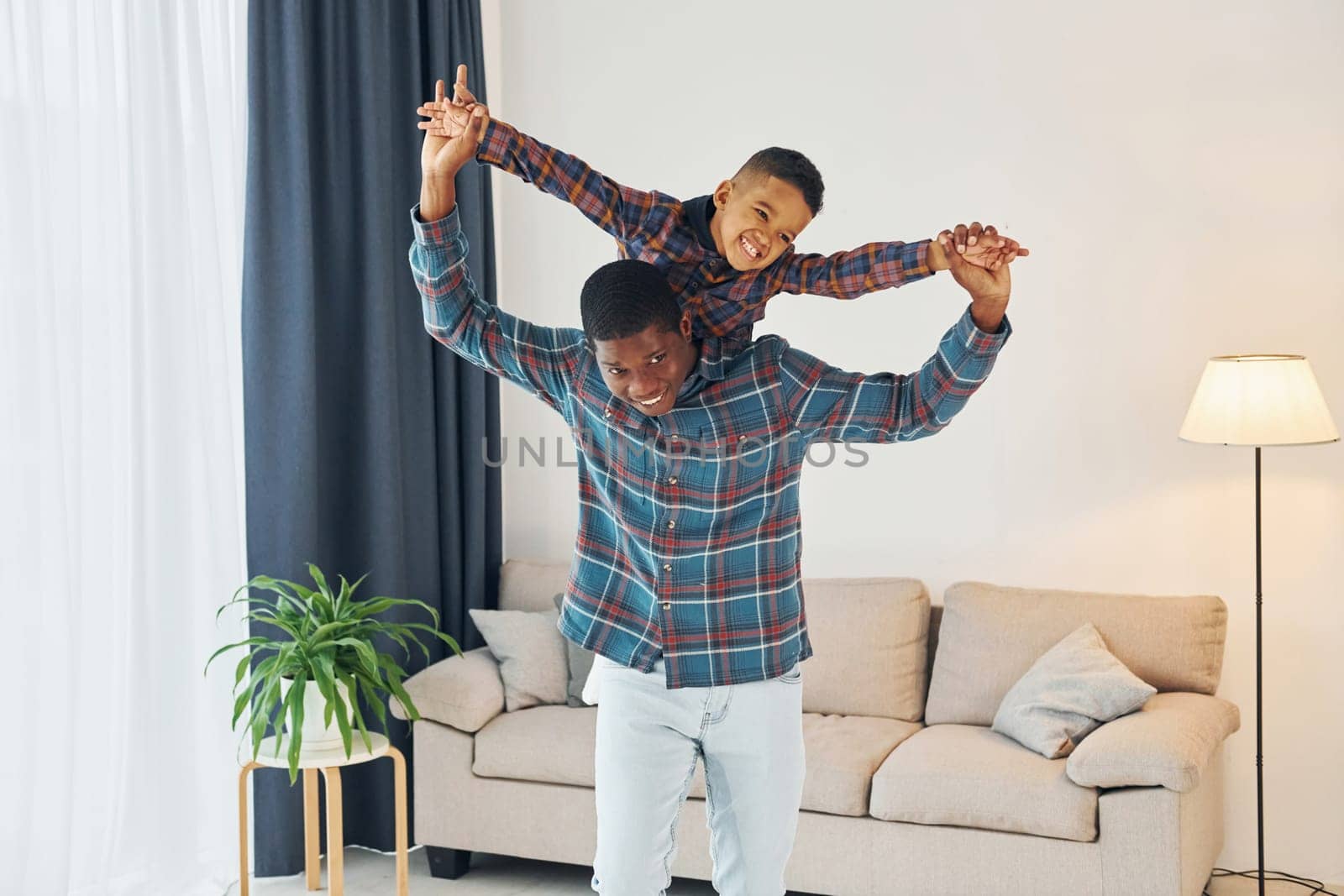 Having fun. African american father with his young son at home.