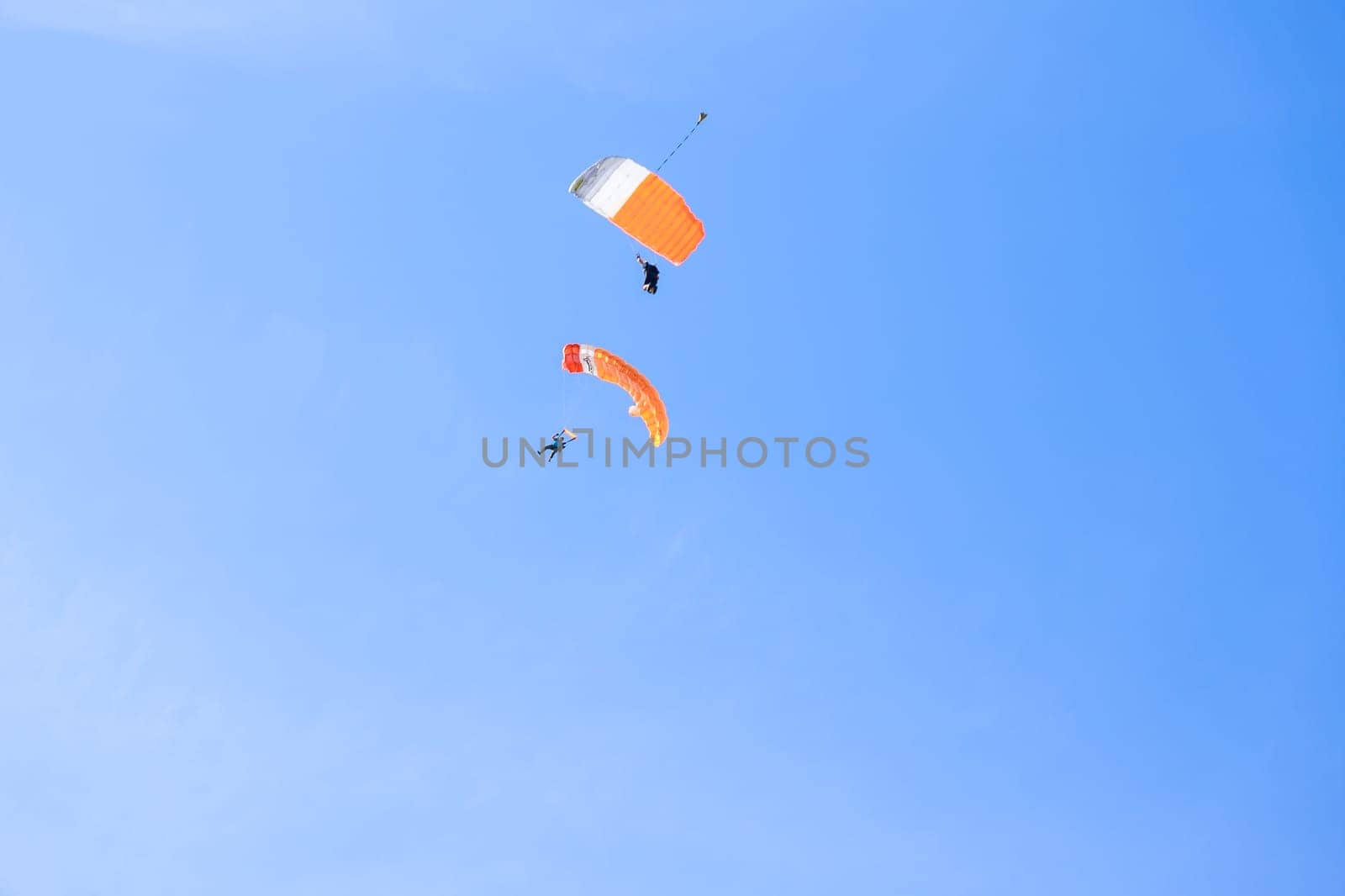 11 July 2021 Skutec, Czech Republic. Two parachutists with yellow parachutes on the background of the blue sky fly to land, sports aerial entertainment. Air sports.