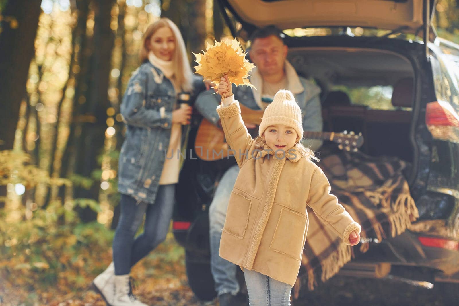 Beautiful leaves. Happy family is in the park at autumn time together.