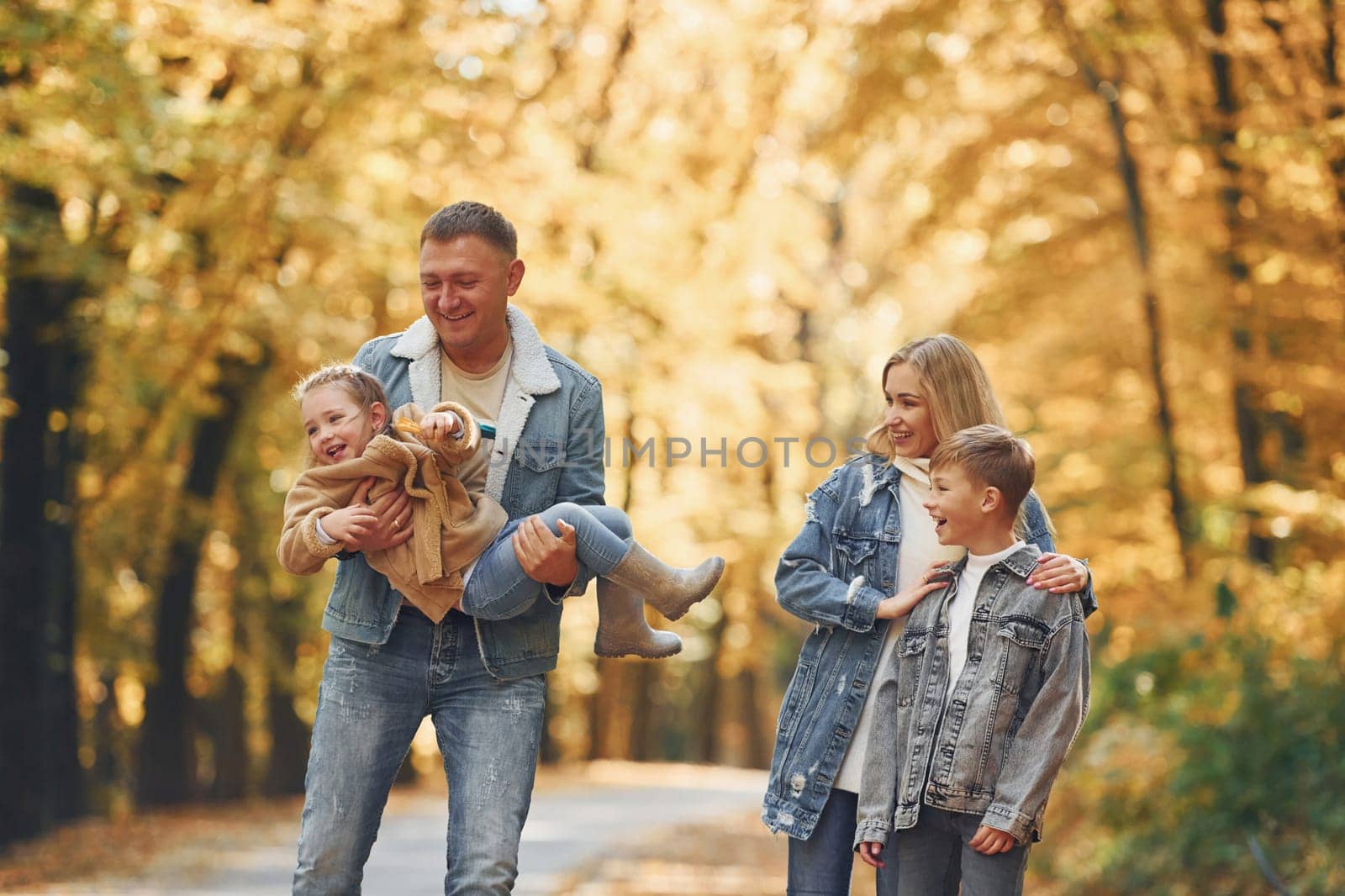 Four people. Happy family is in the park at autumn time together.