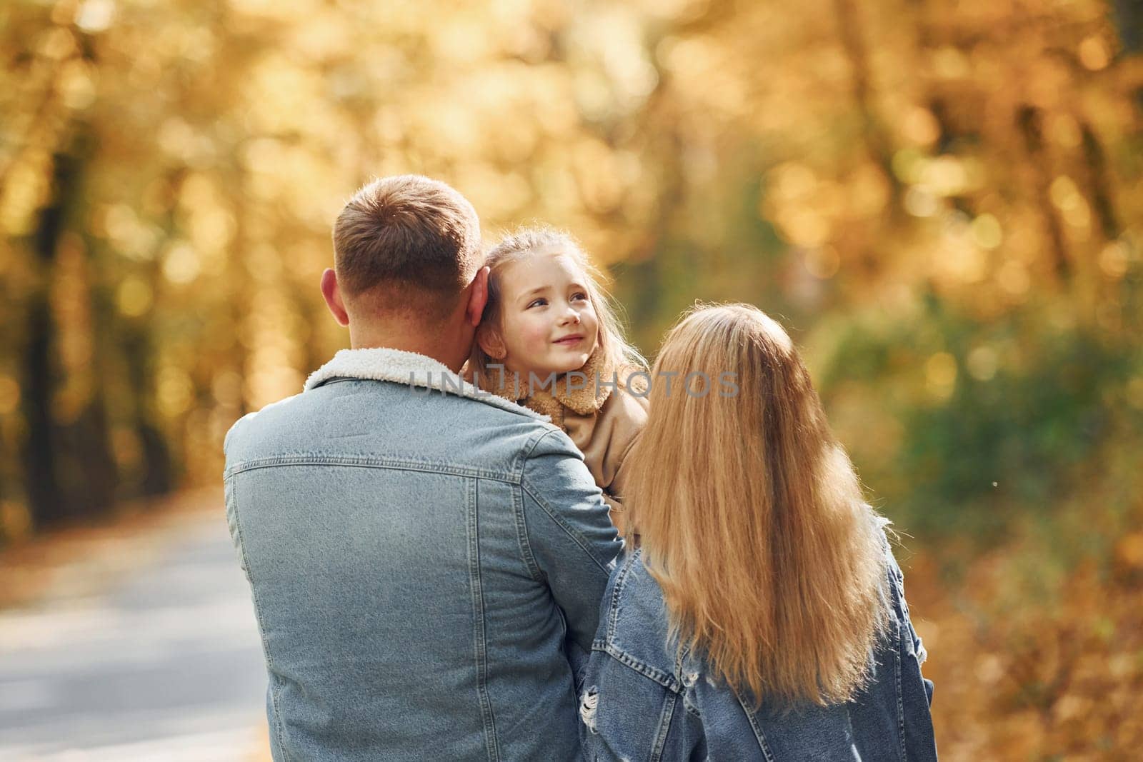 Happy family is in the park at autumn time together.