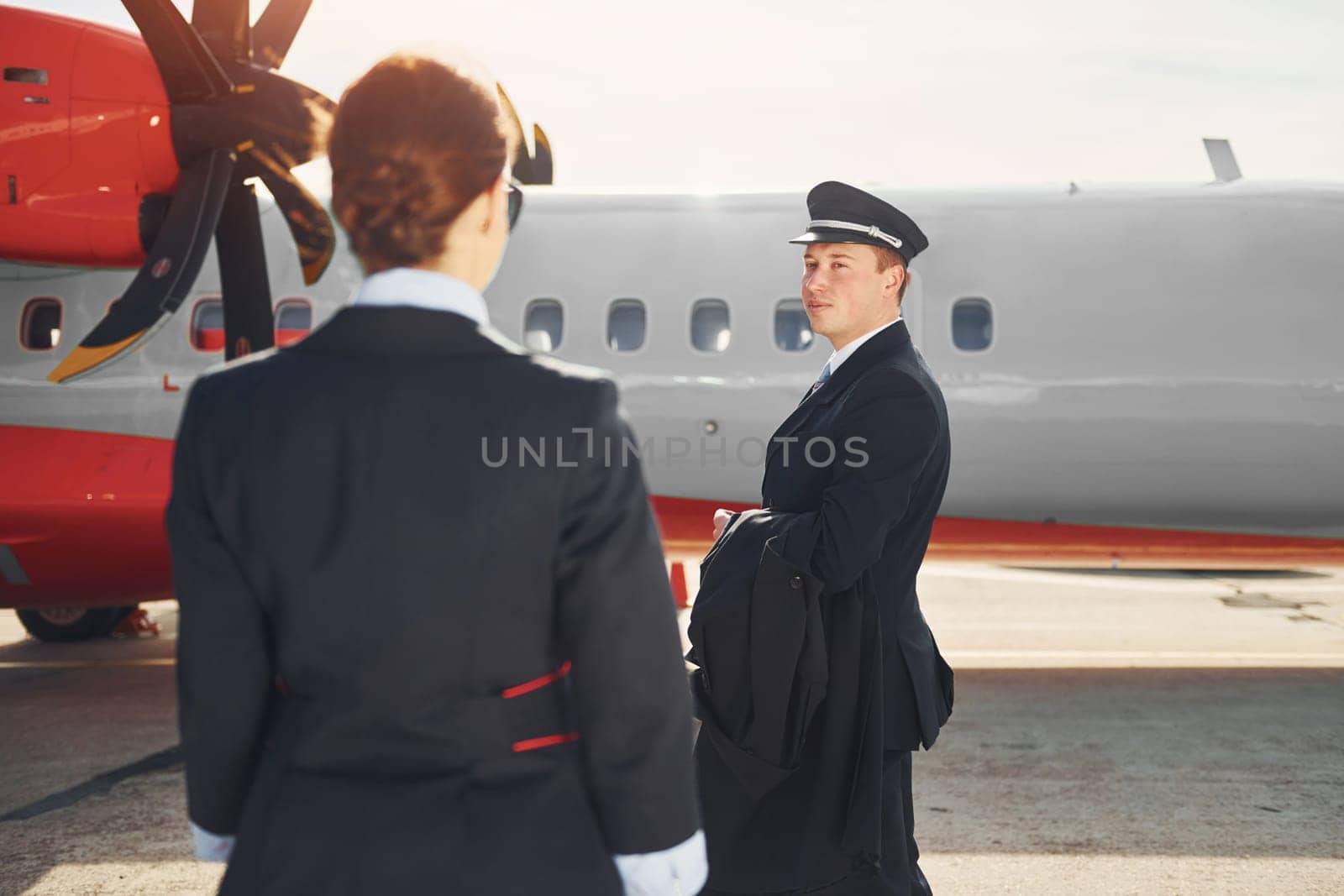 Pilot and stewardess. Crew of airport and plane workers in formal clothes standing outdoors together.