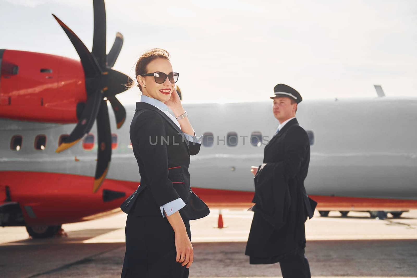 Pilot and stewardess. Crew of airport and plane workers in formal clothes standing outdoors together.