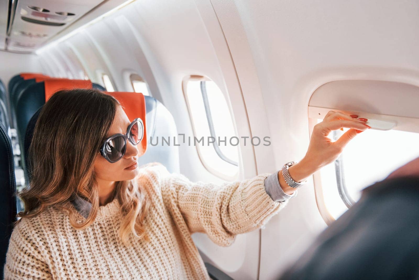 Young tourist. Female passanger in casual clothes is in the plane.