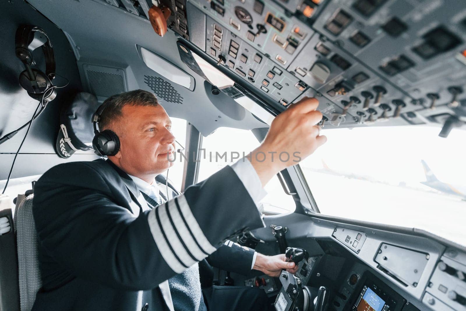 Side view. A professional pilot is in the cockpit. Conception of work.