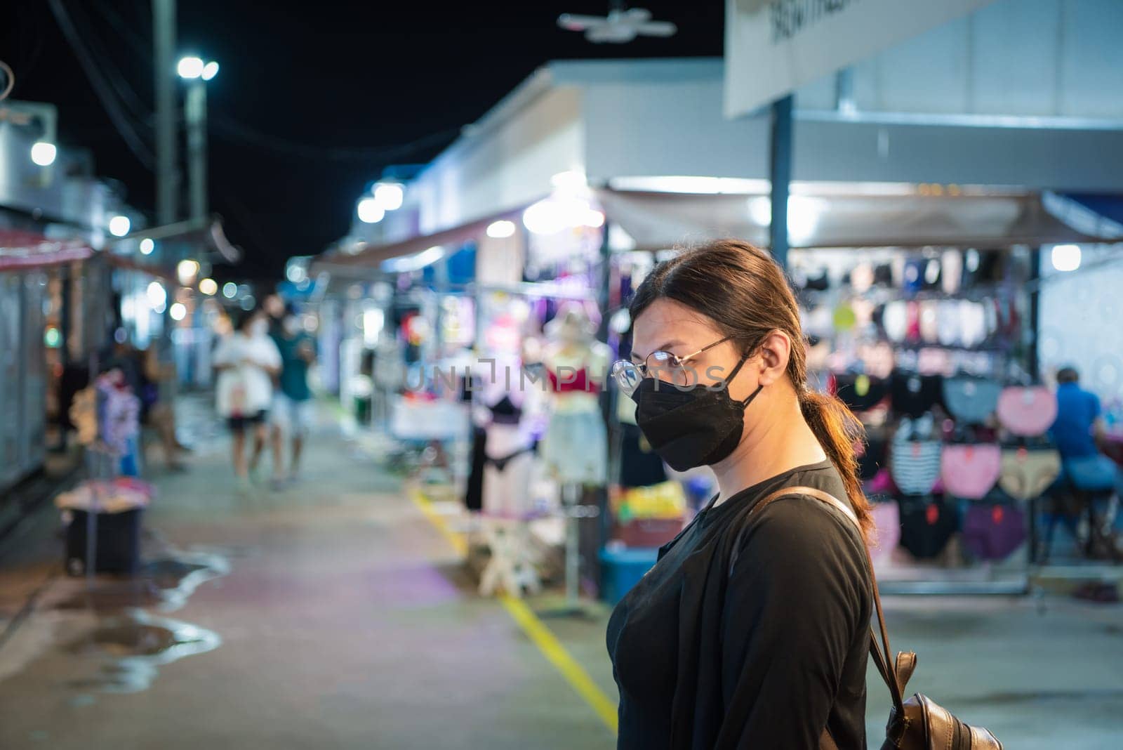 Beautiful asian woman (LGBTQ) natural makeup wear fashion yellow leather clothes with glasses posing with food or drink at thai street food, market or restaurant outdoor fashion style