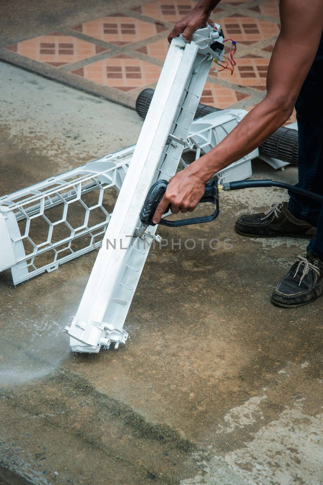 Worker to cleaning coil cooler of air conditioner by water for clean a dust on the wall in customer home when maintenance service