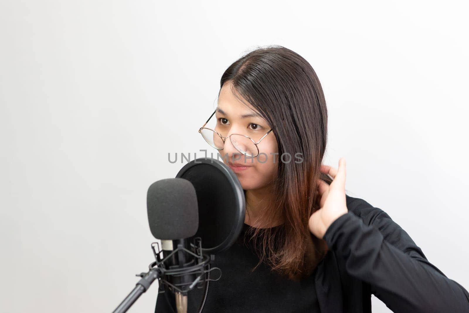 Beautiful asian woman (LGBTQ) is a singer. She enjoying sing a song or karaoke in music studio with microphone condenser and headphones for fun or voice creative