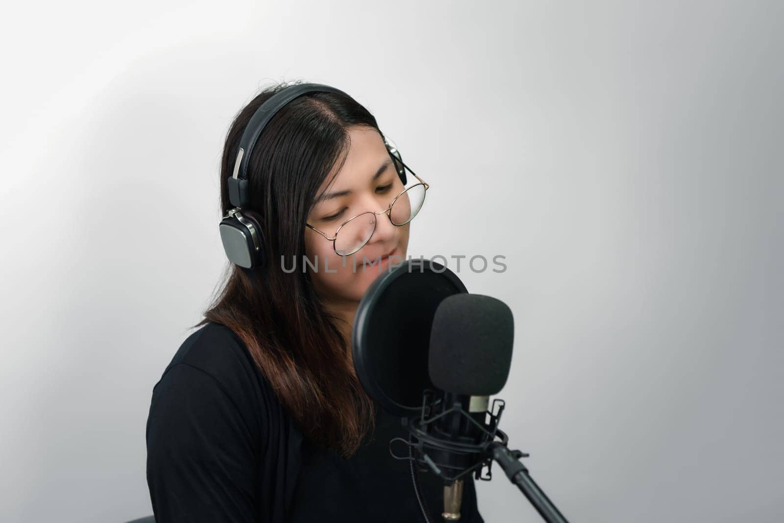 Beautiful asian woman (LGBTQ) is a singer. She enjoying sing a song or karaoke in music studio with microphone condenser and headphones for fun or voice creative