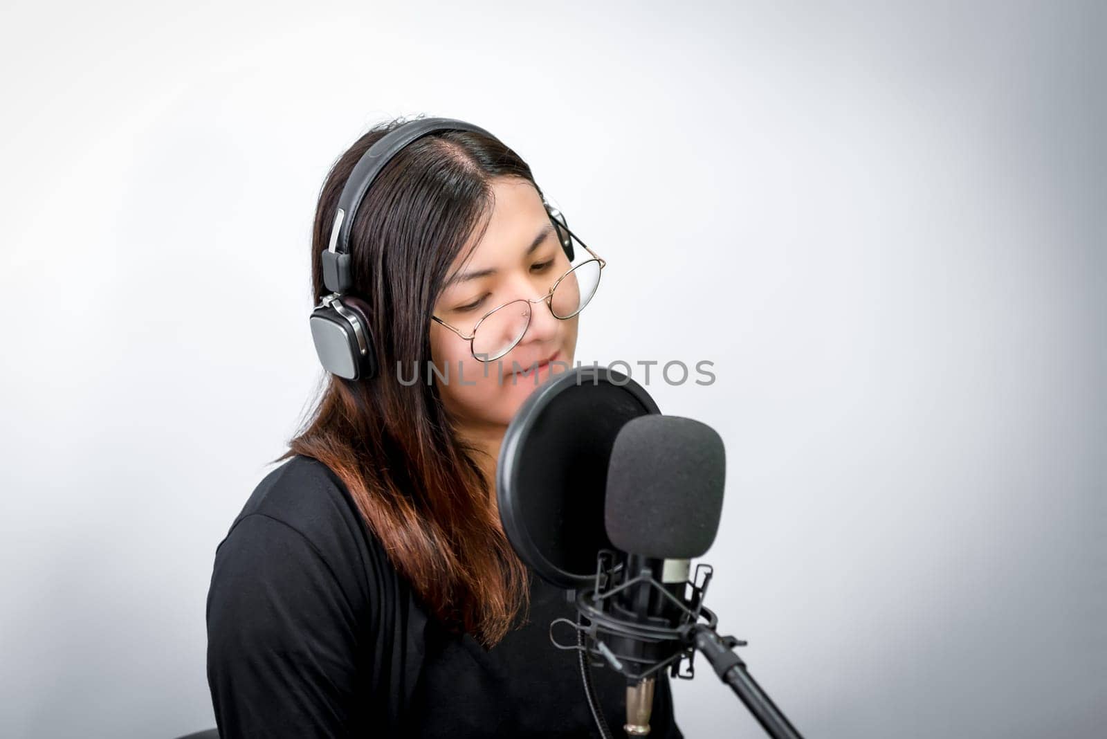 Beautiful asian woman (LGBTQ) is a singer. She enjoying sing a song or karaoke in music studio with microphone condenser and headphones for fun or voice creative